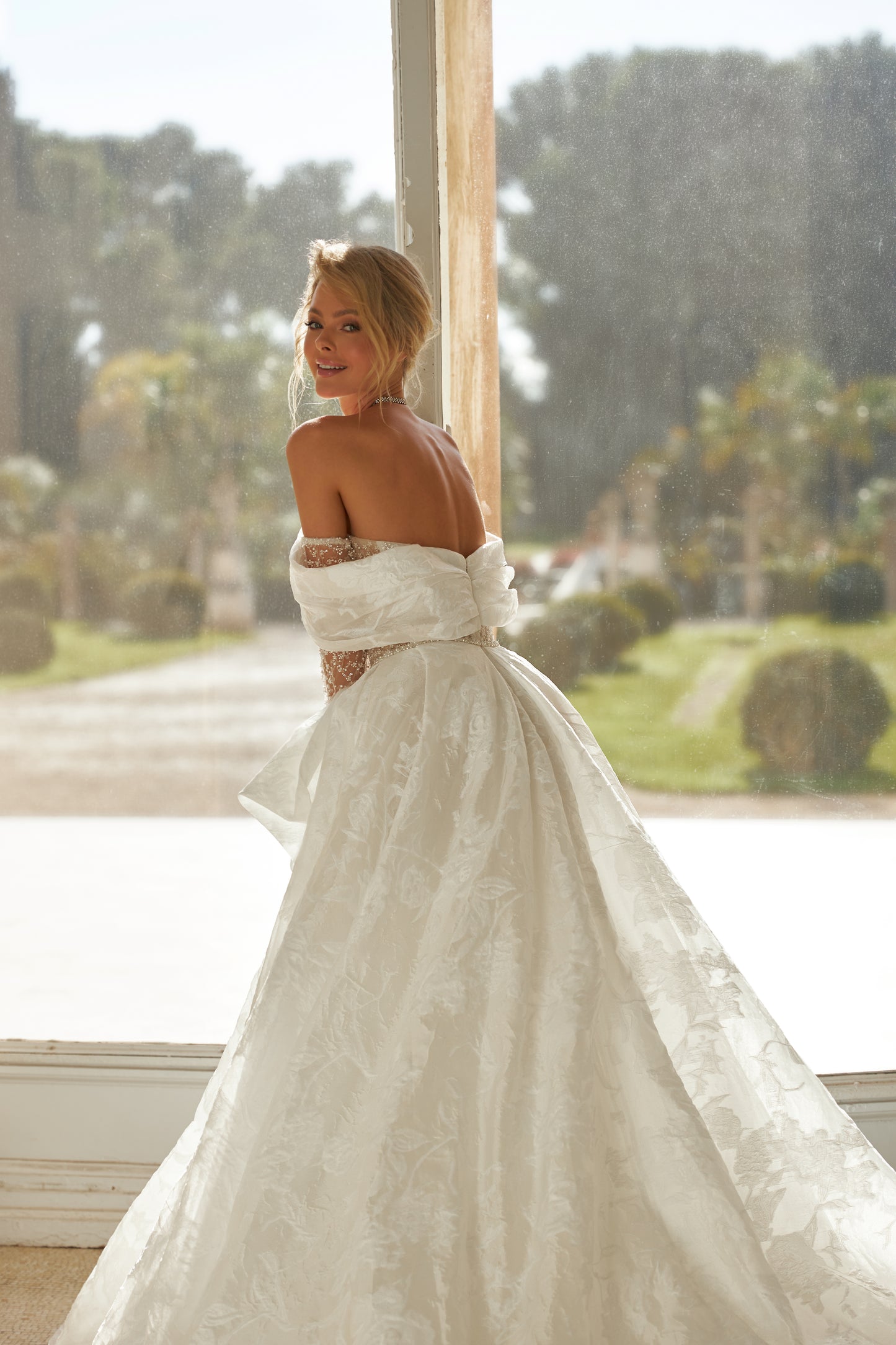 A-line wedding dress with open back, illusion sleeves.