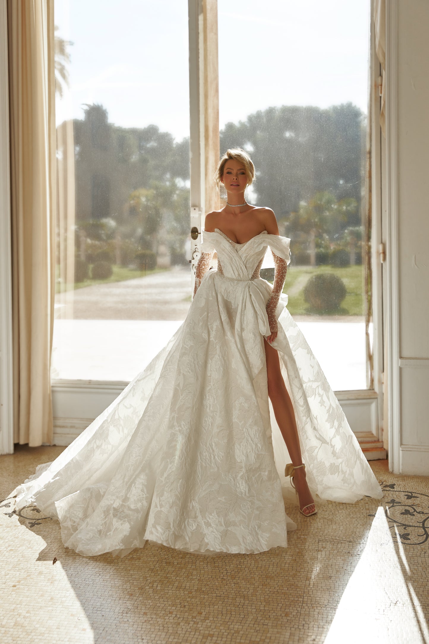 A-line wedding dress with open back, illusion sleeves.