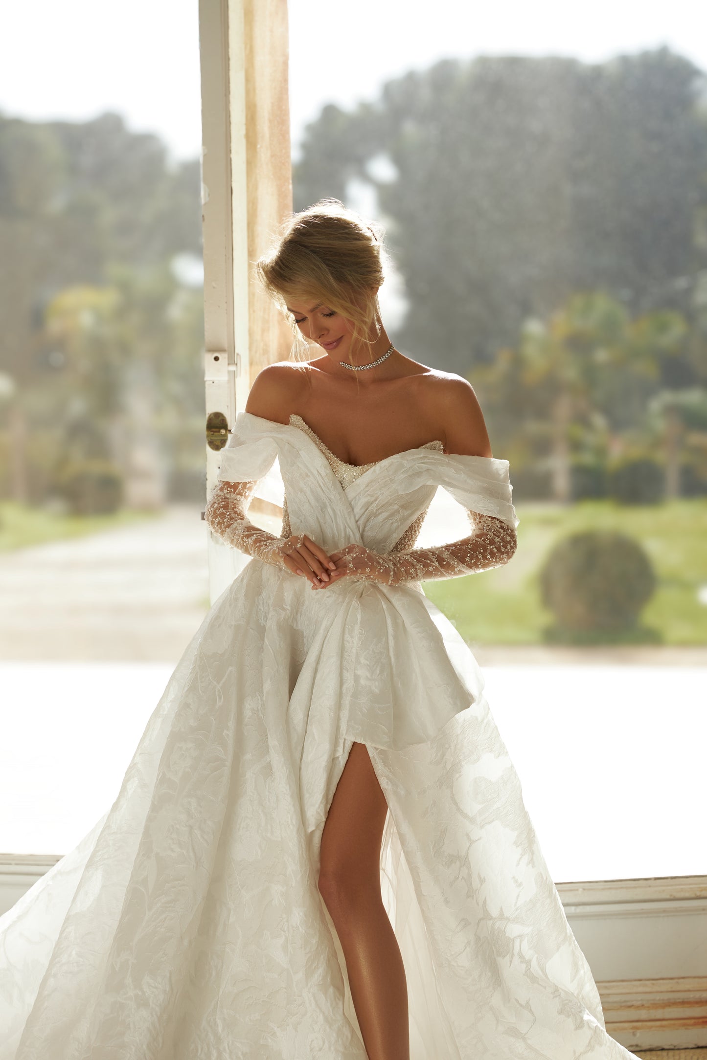A-line wedding dress with open back, illusion sleeves.