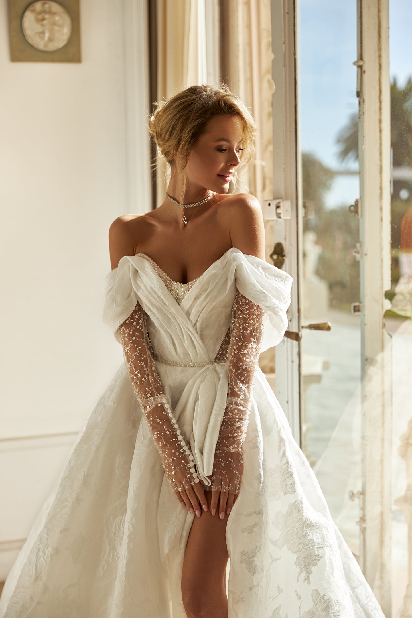 A-line wedding dress with open back, illusion sleeves.