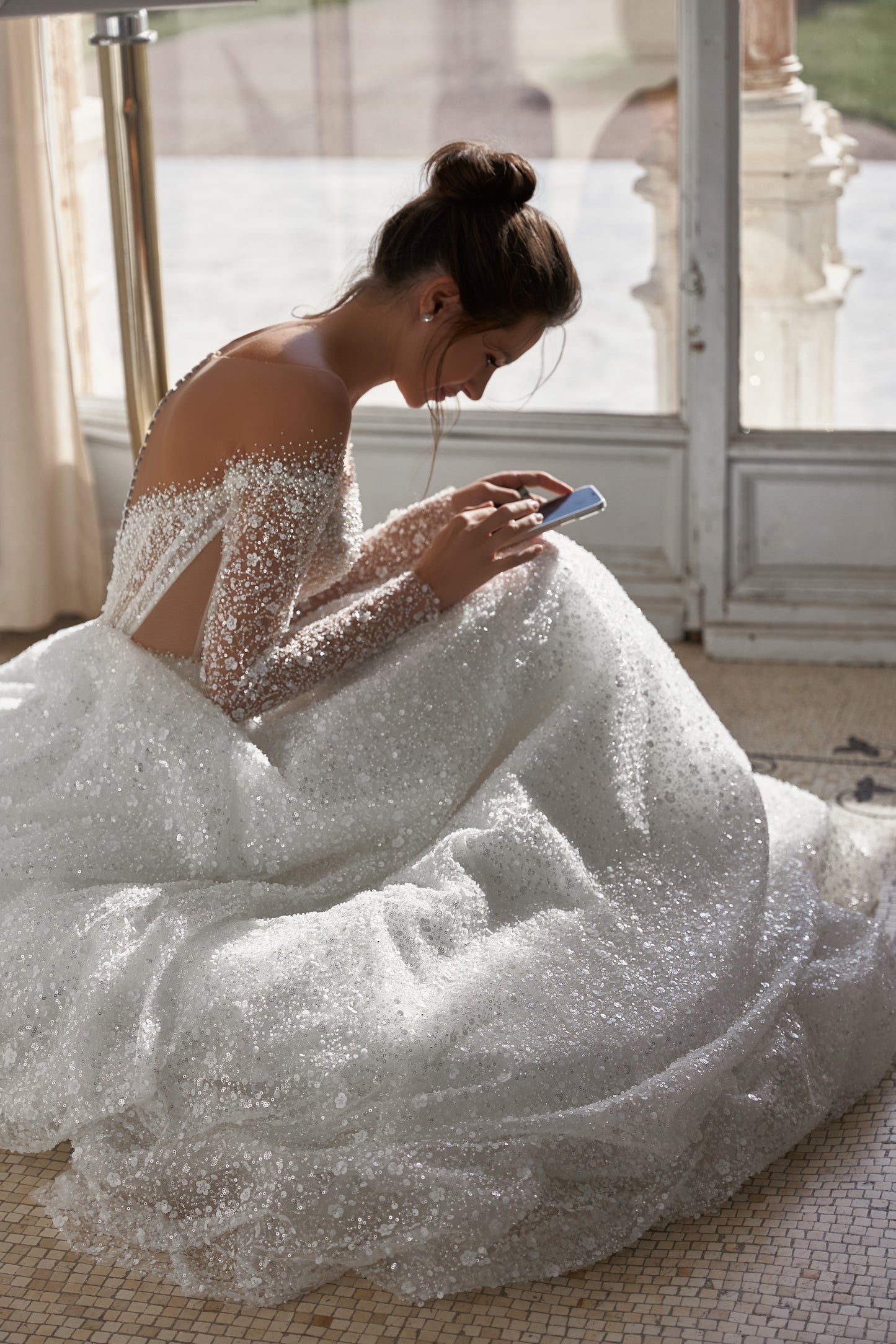 A-line wedding dress with illusion sleeves and sequin details.