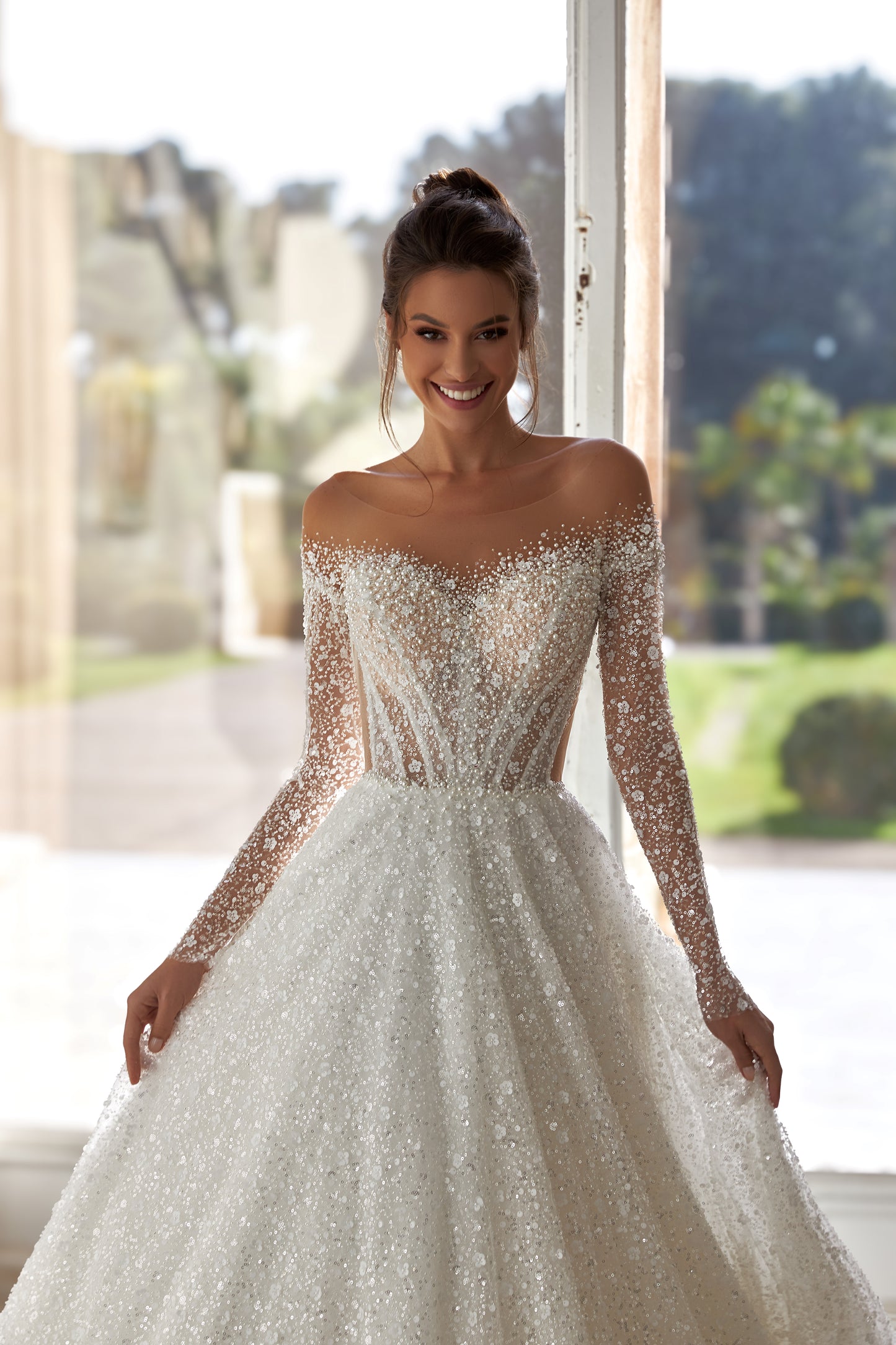 A-line wedding dress with illusion sleeves and sequin details.