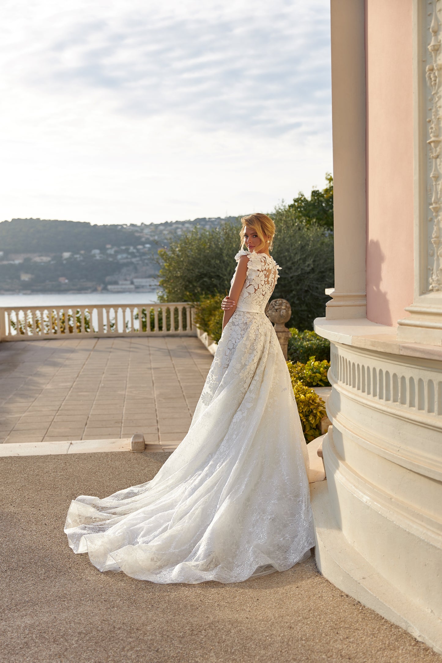 A-line lace wedding dress with cape and beaded details.