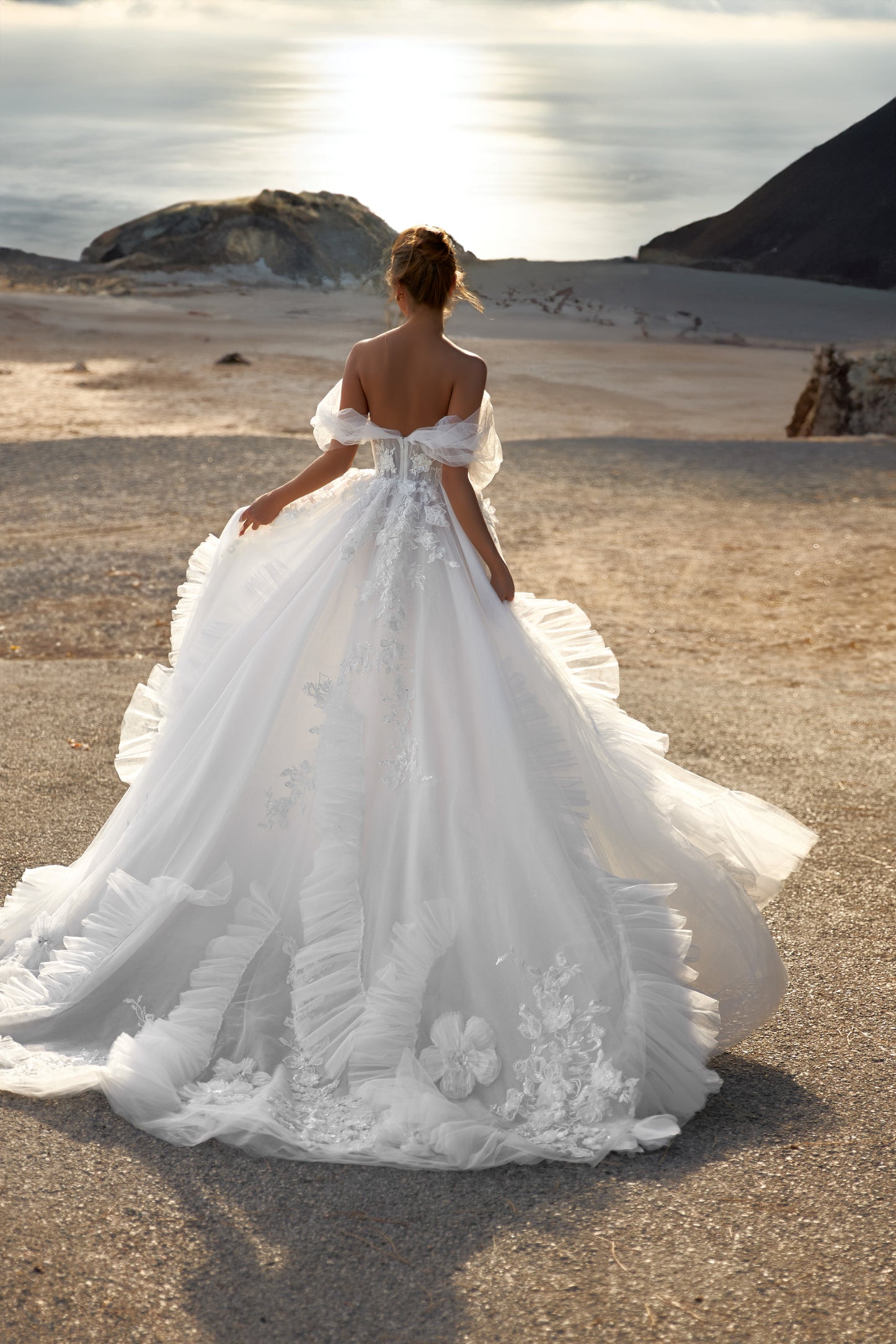A-line tulle wedding dress with chapel train and wrap skirt.