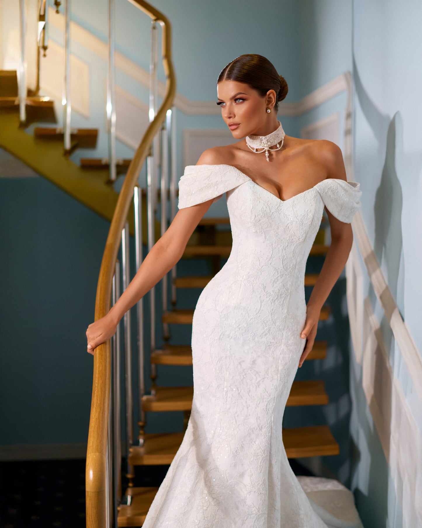 Full-length lace mermaid wedding dress with fit and flare silhouette, draped off-shoulder sleeves, V-neckline, removable lace and pearl choker, lace-up back closure, and elegant fishtail train for modern bridal look