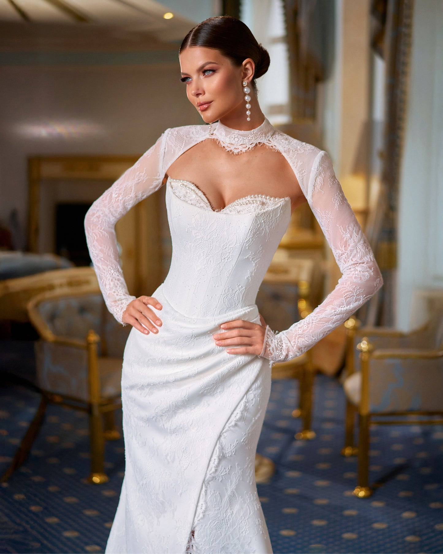Bride in fitted lace wedding dress with sweetheart neckline, removable long-sleeve lace bolero, thigh-high slit, and chapel train.