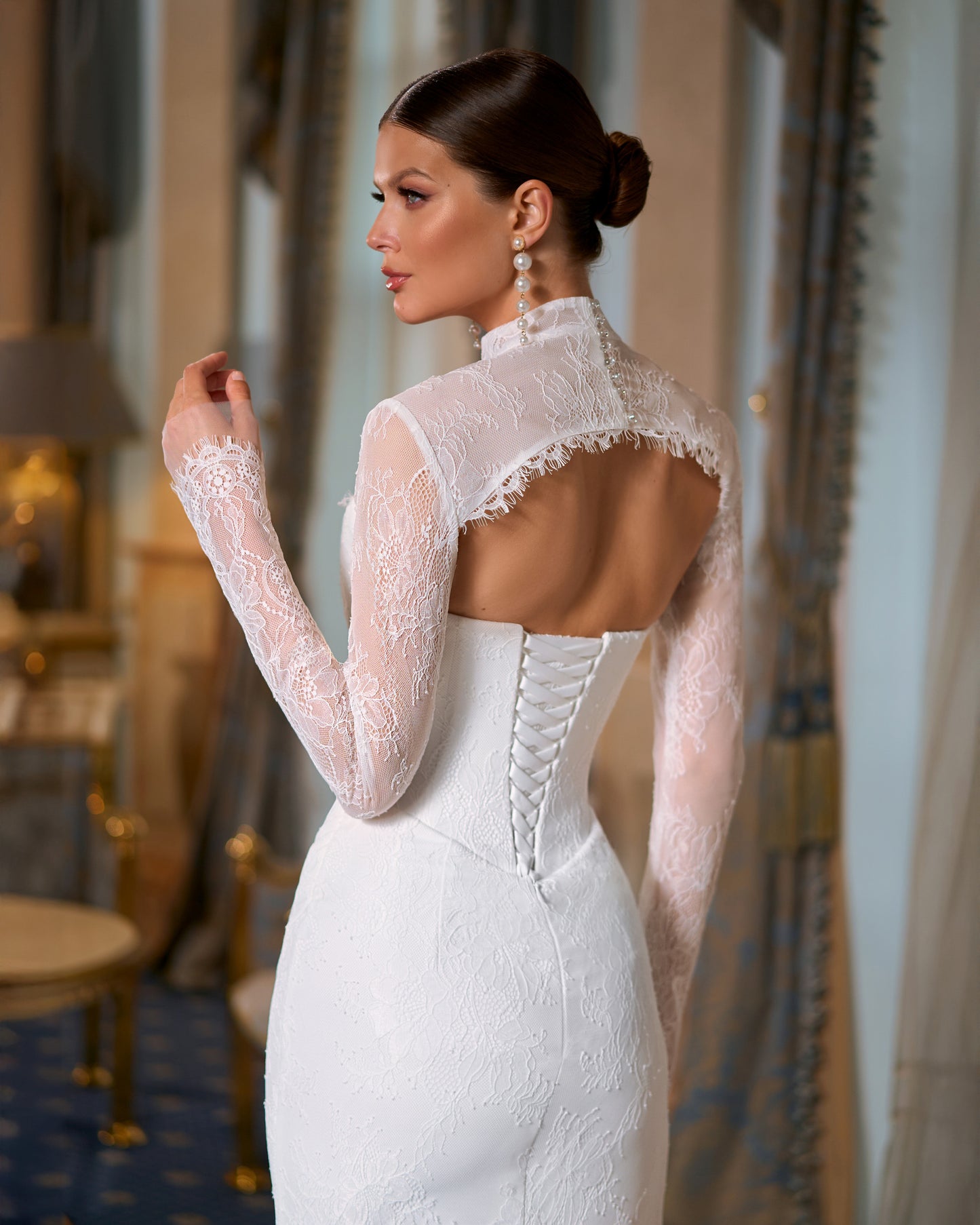 Bride in fitted lace wedding dress with sweetheart neckline, removable long-sleeve lace bolero, thigh-high slit, and chapel train.