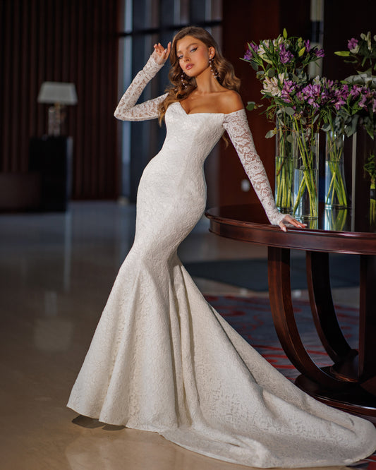 Off the shoulder lace mermaid wedding dress with long sleeves.