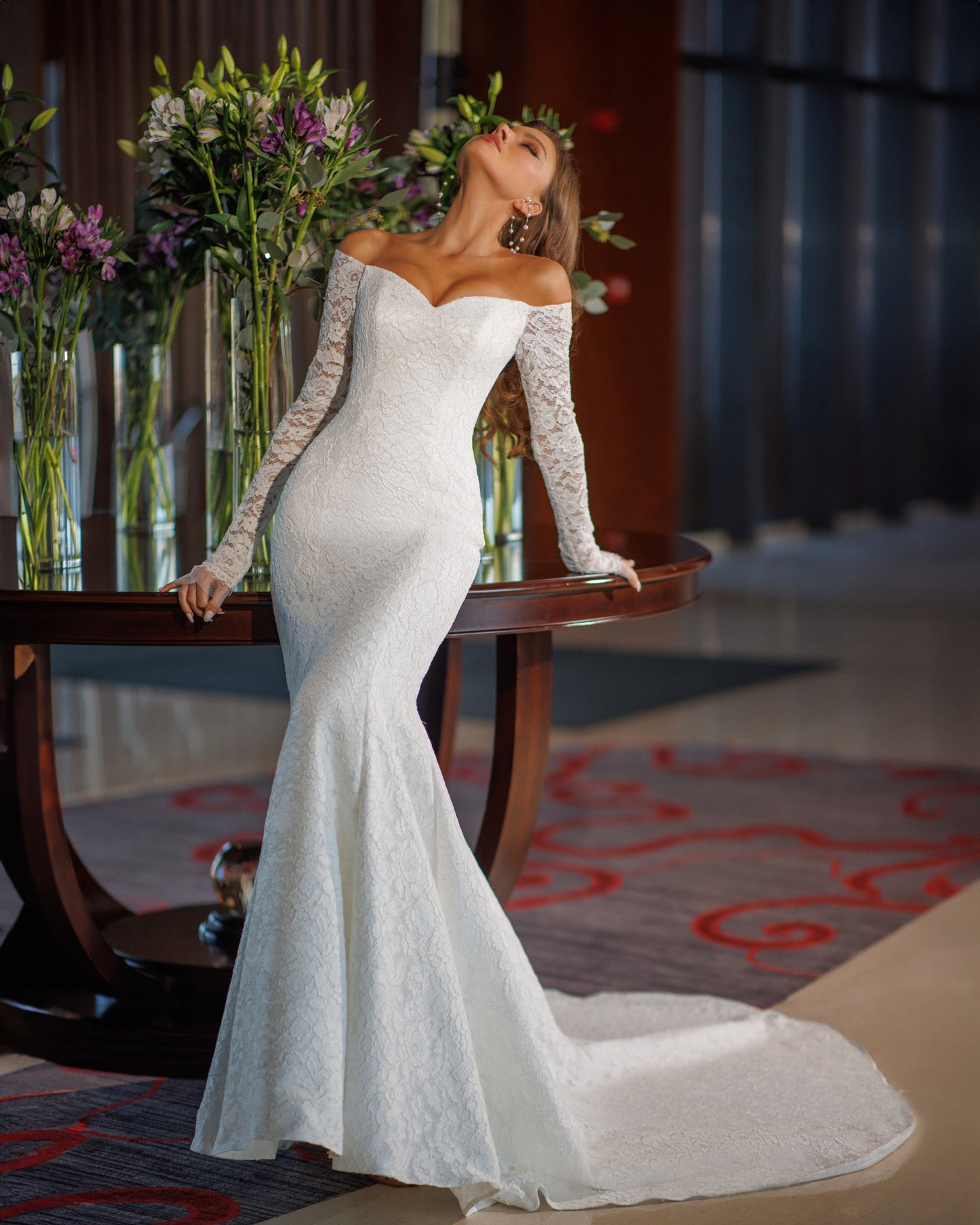 Off the shoulder lace mermaid wedding dress with long sleeves.