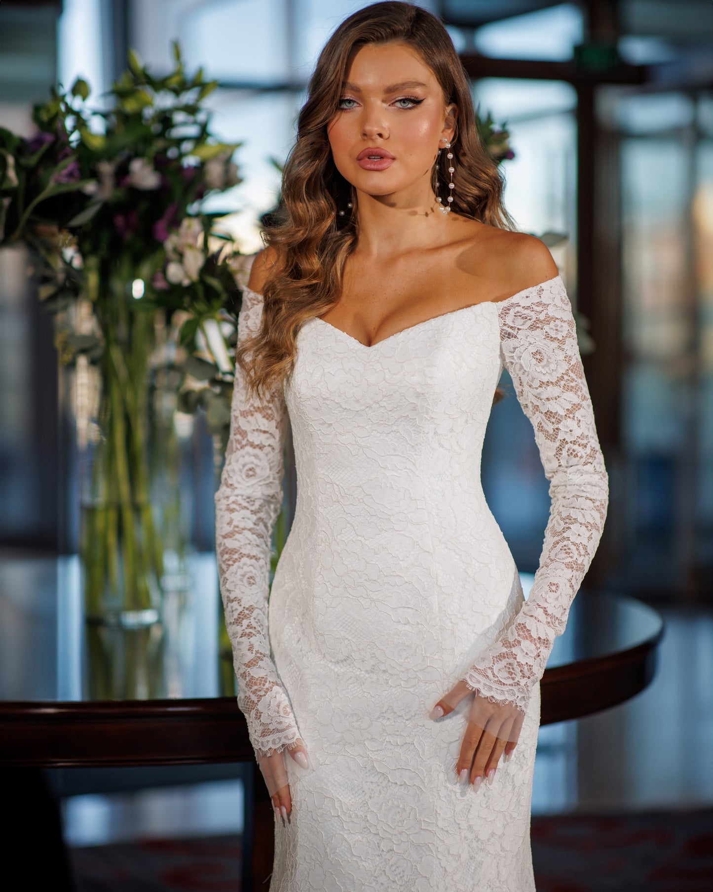 Off the shoulder lace mermaid wedding dress with long sleeves.