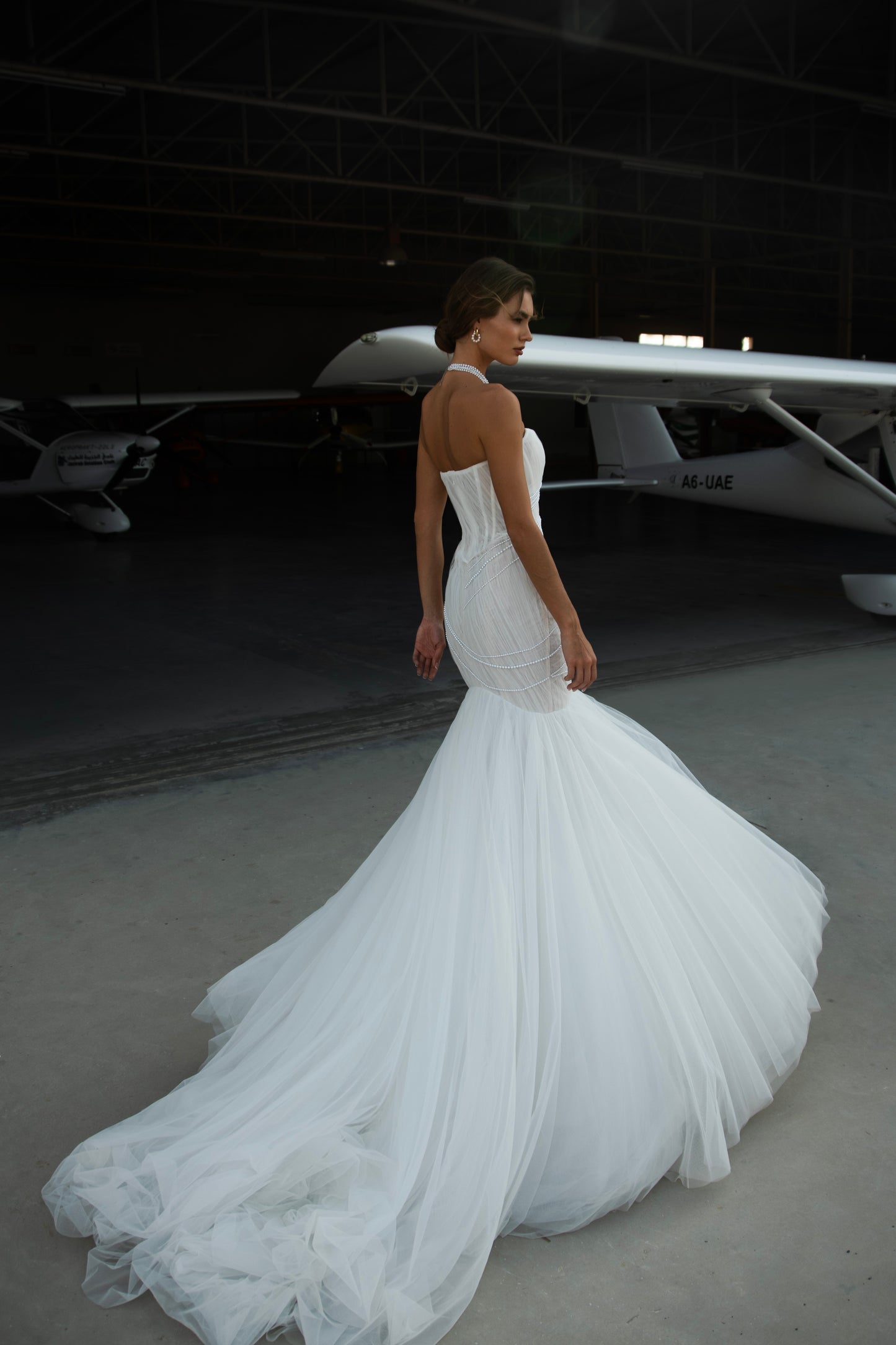 Strapless mermaid wedding dress with corrugated tulle, pearl detailing, fit and flare silhouette, and sweeping fishtail train for striking modern bridal look