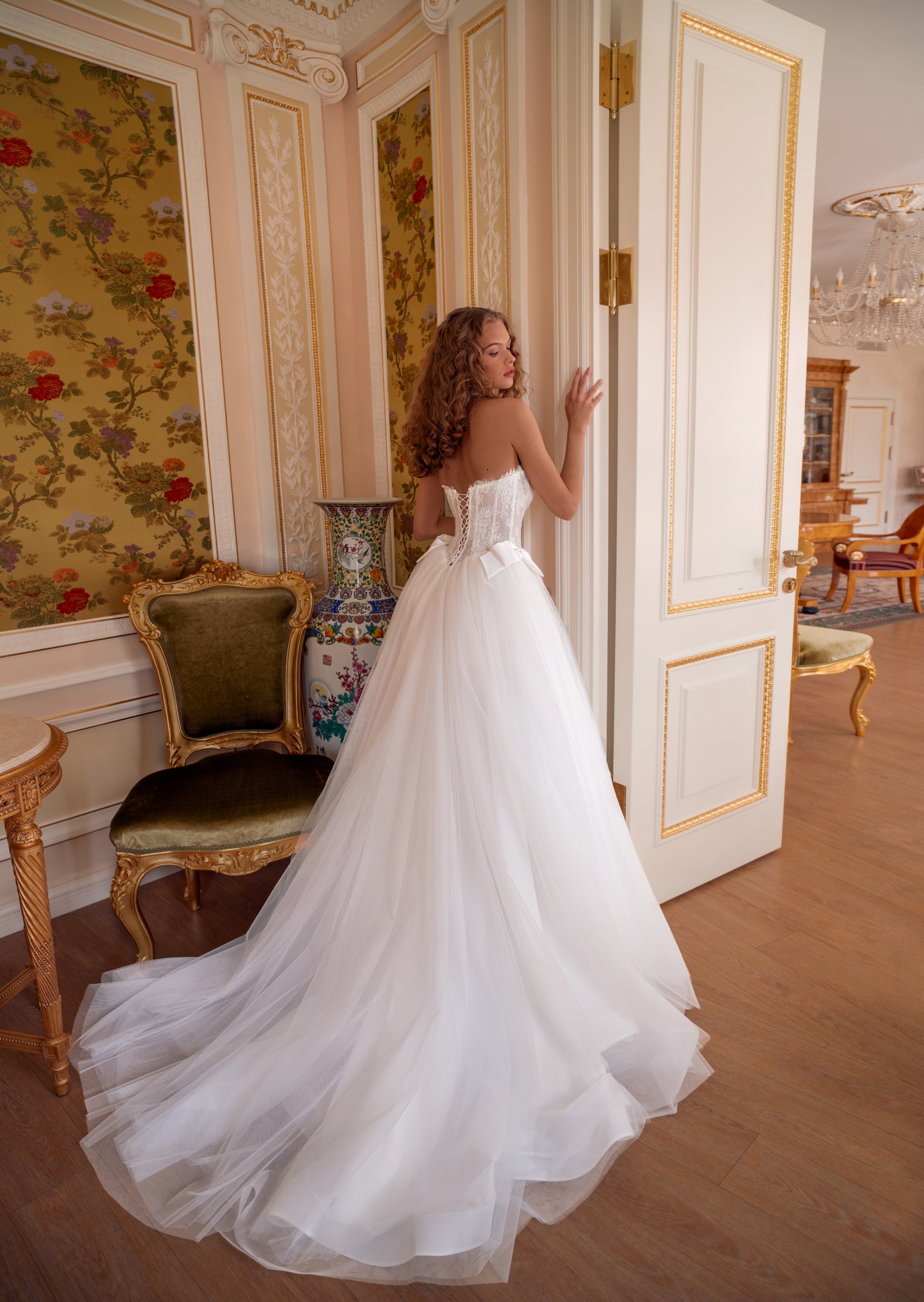 Strapless lace corset wedding gown with satin bows and voluminous tulle skirt.