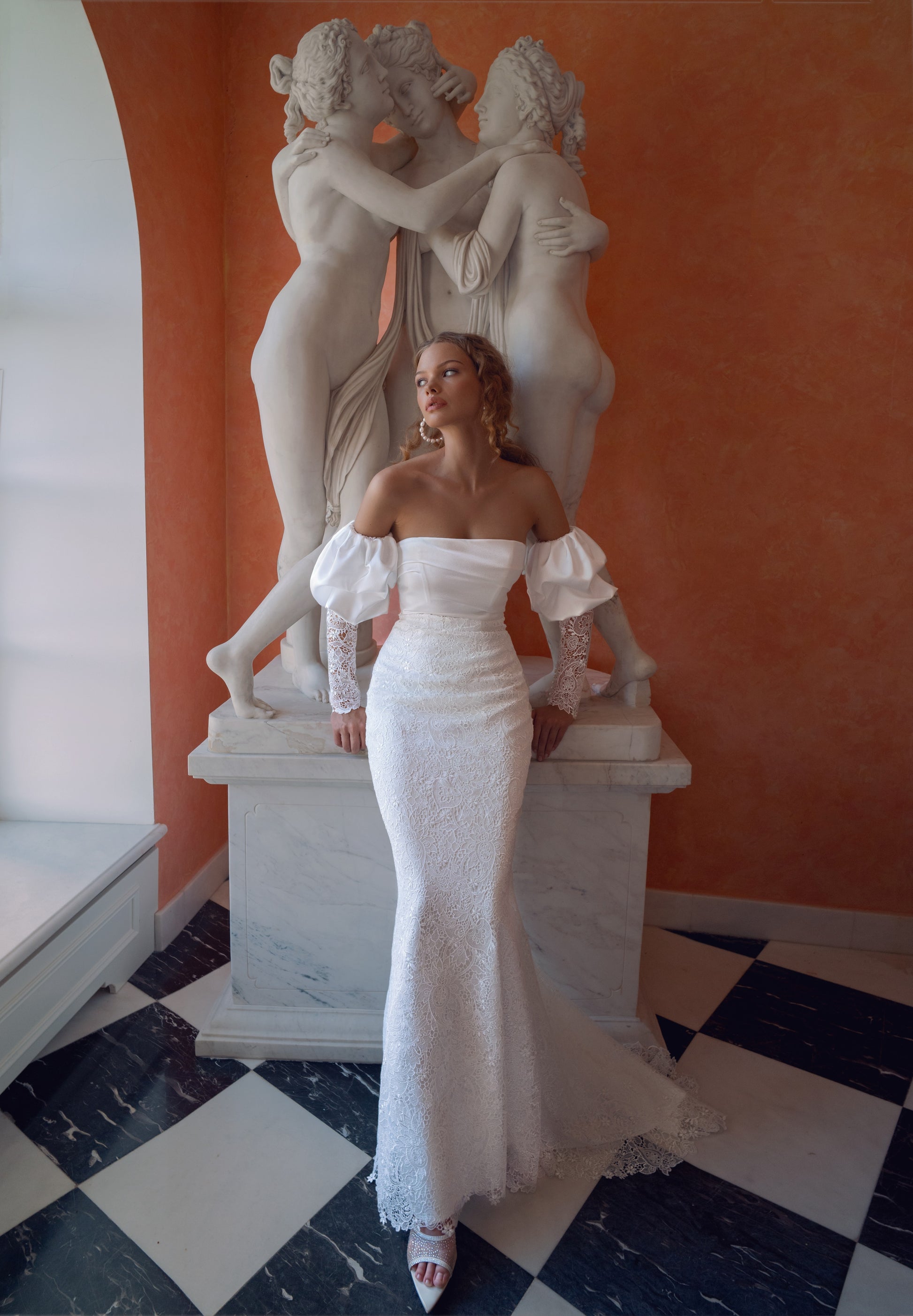 Off-shoulder lace wedding gown with puffed sleeves and fitted silhouette.