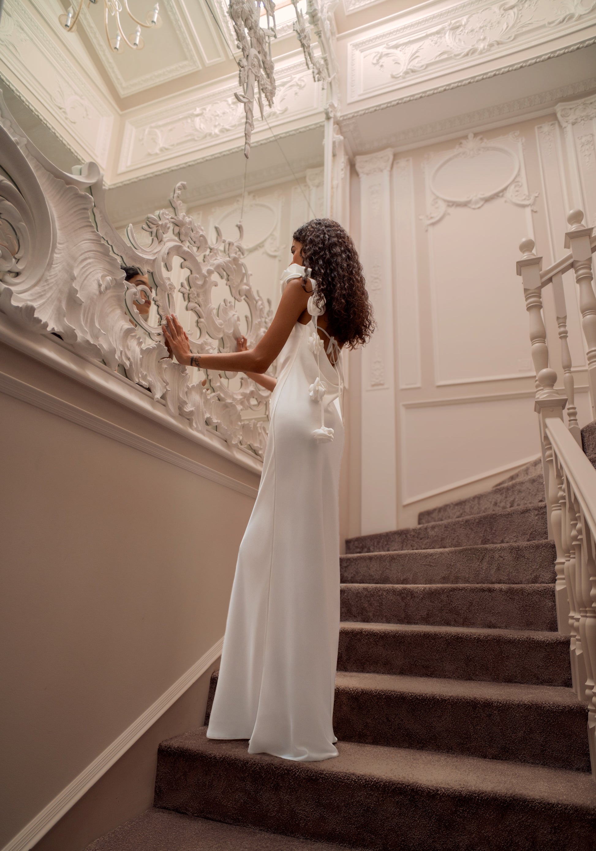 Minimalist silk wedding gown with sculpted rose shoulder and open back.