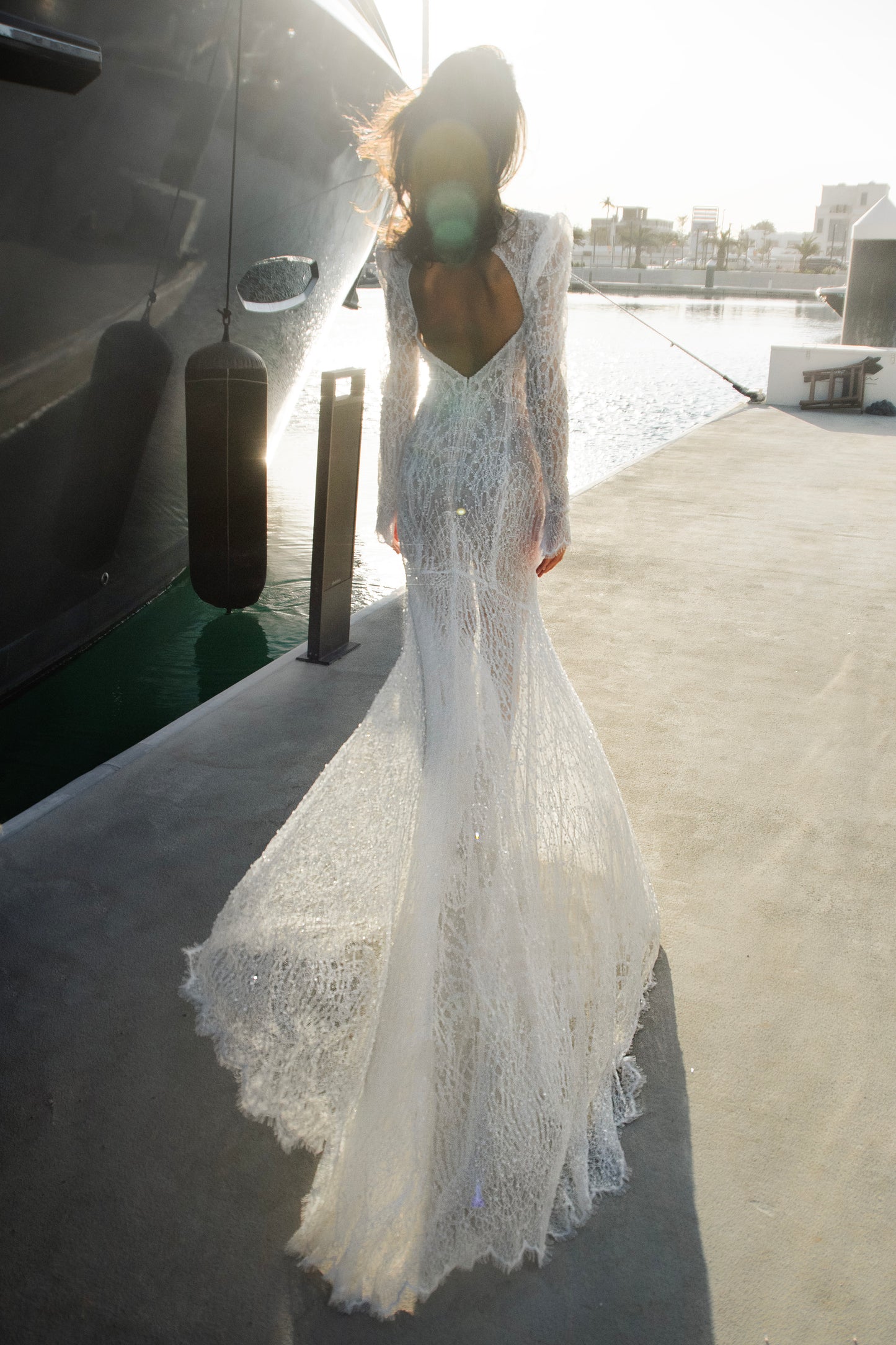 Celeste beaded lace long-sleeve sheath wedding dress with high neck and detachable tulle overskirt, open-back detail.
