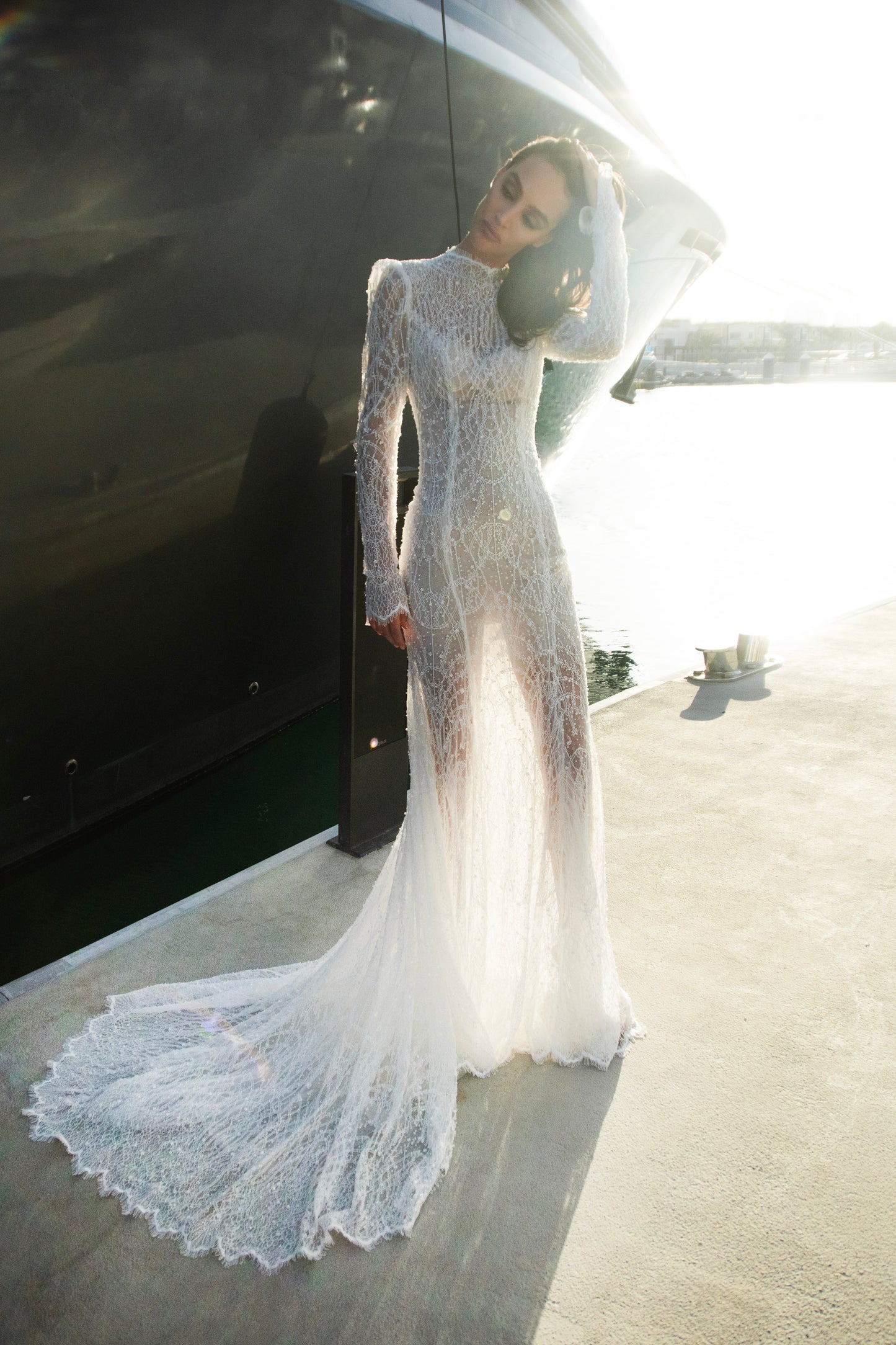 Celeste beaded lace long-sleeve sheath wedding dress with high neck and detachable tulle overskirt, open-back detail.