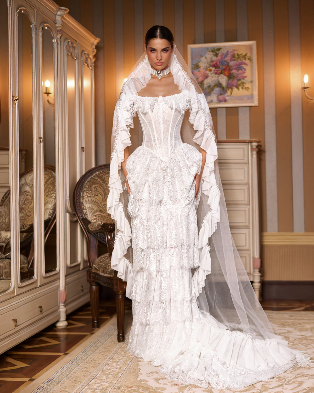 Fit-and-flare lace corset wedding dress with tiered skirt, ruffled hem train and ruffle-edged tulle veil
