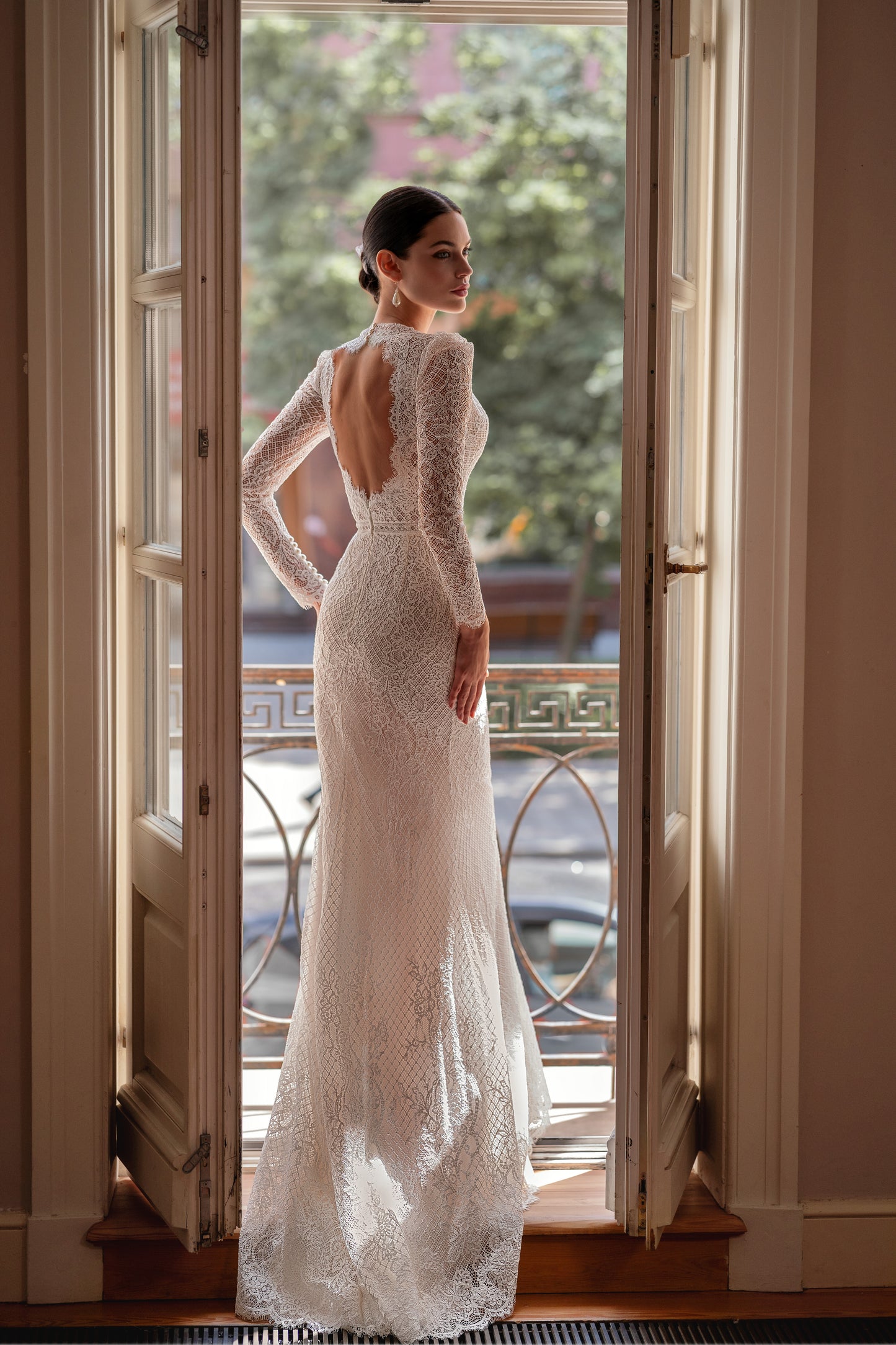 Mermaid wedding dress with lace, long sleeves, and open back