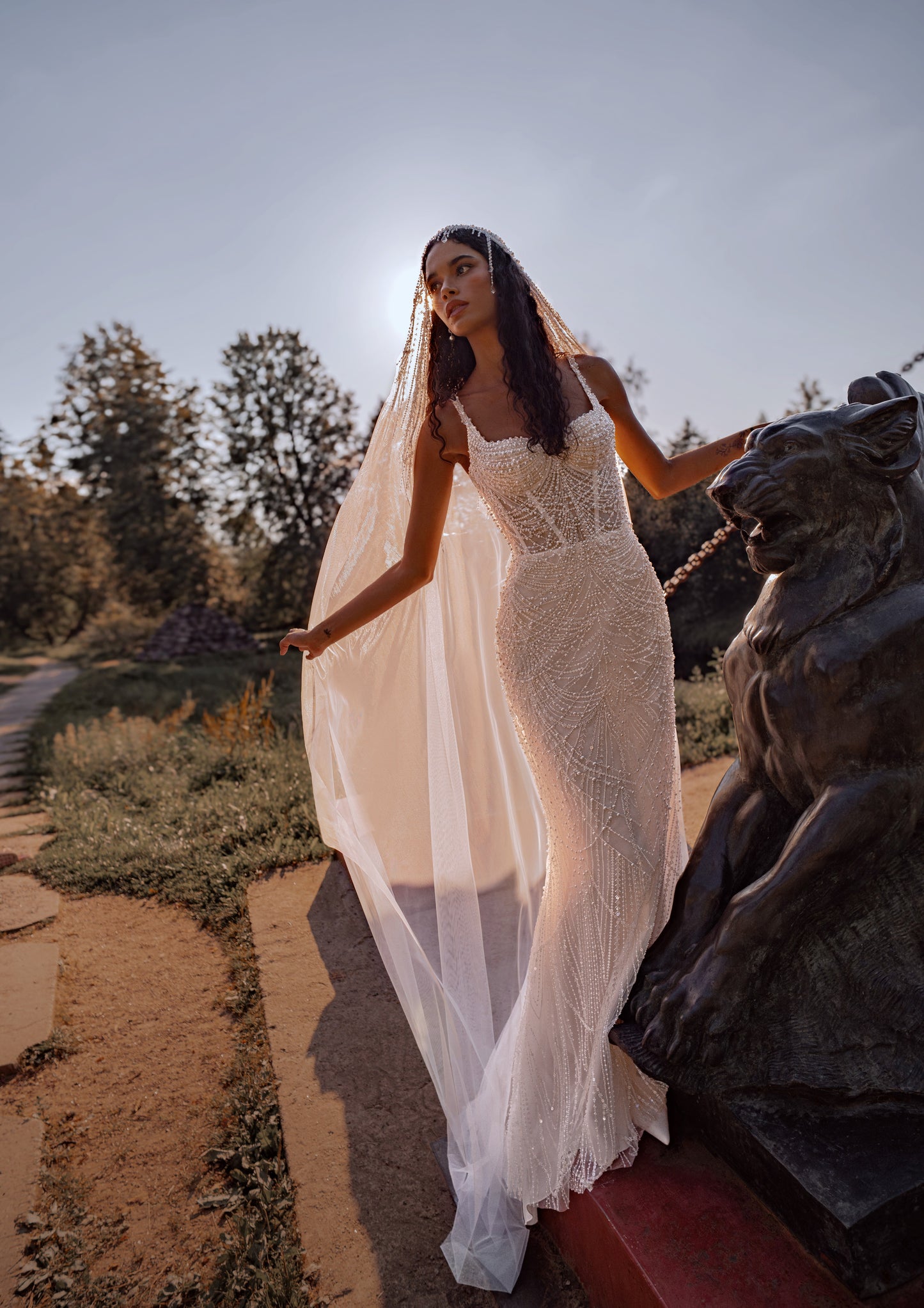 Beaded mermaid wedding gown with geometric pearl embroidery, sheer corset bodice, and elegant train.