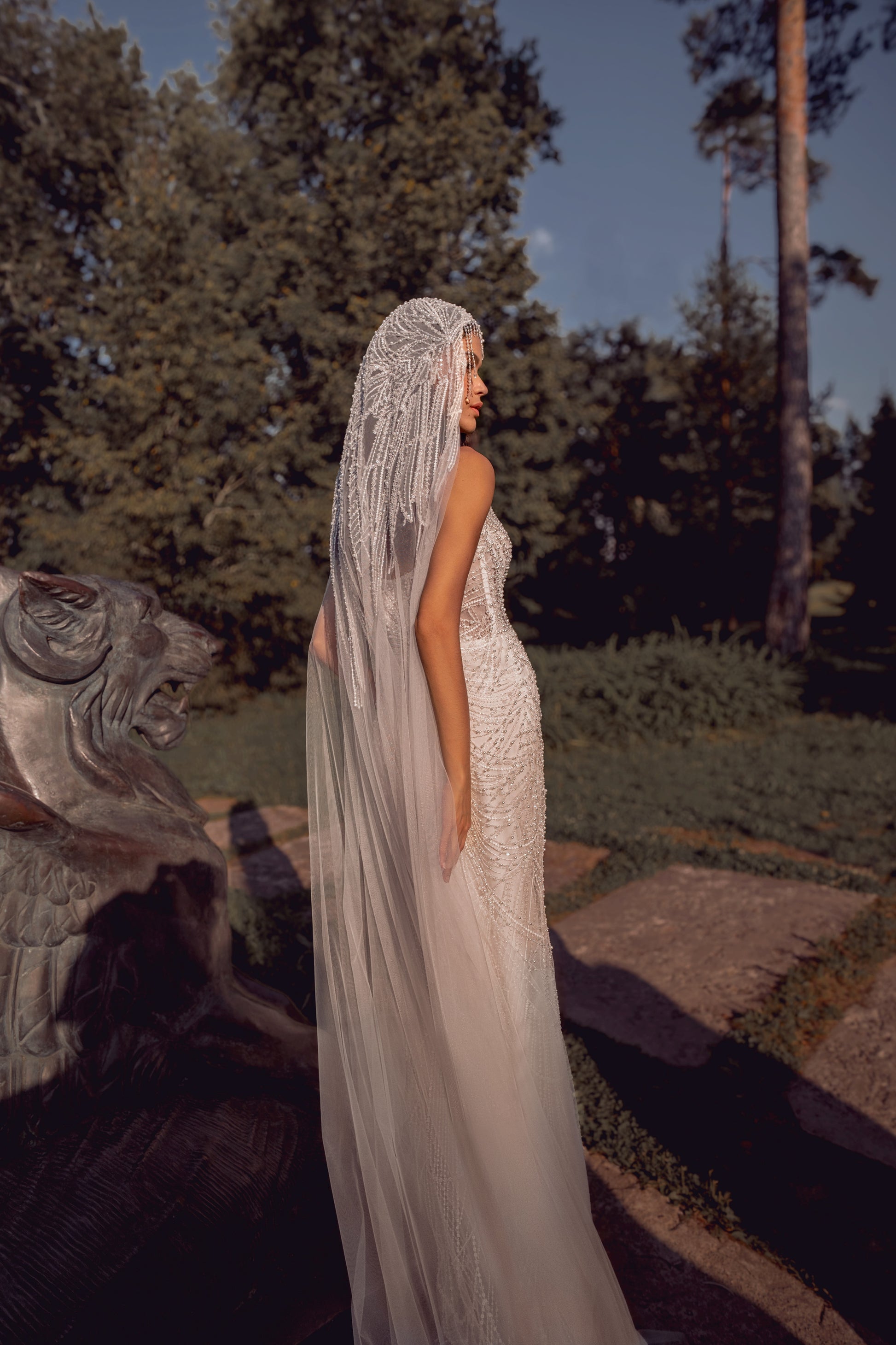 Beaded mermaid wedding gown with geometric pearl embroidery, sheer corset bodice, and elegant train.