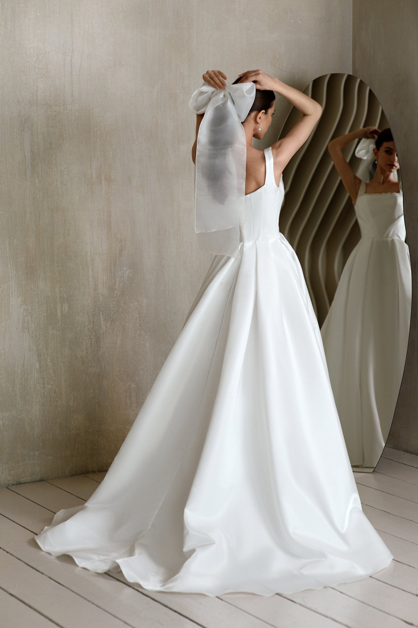 Minimalist sleeveless A-line wedding dress with court train.