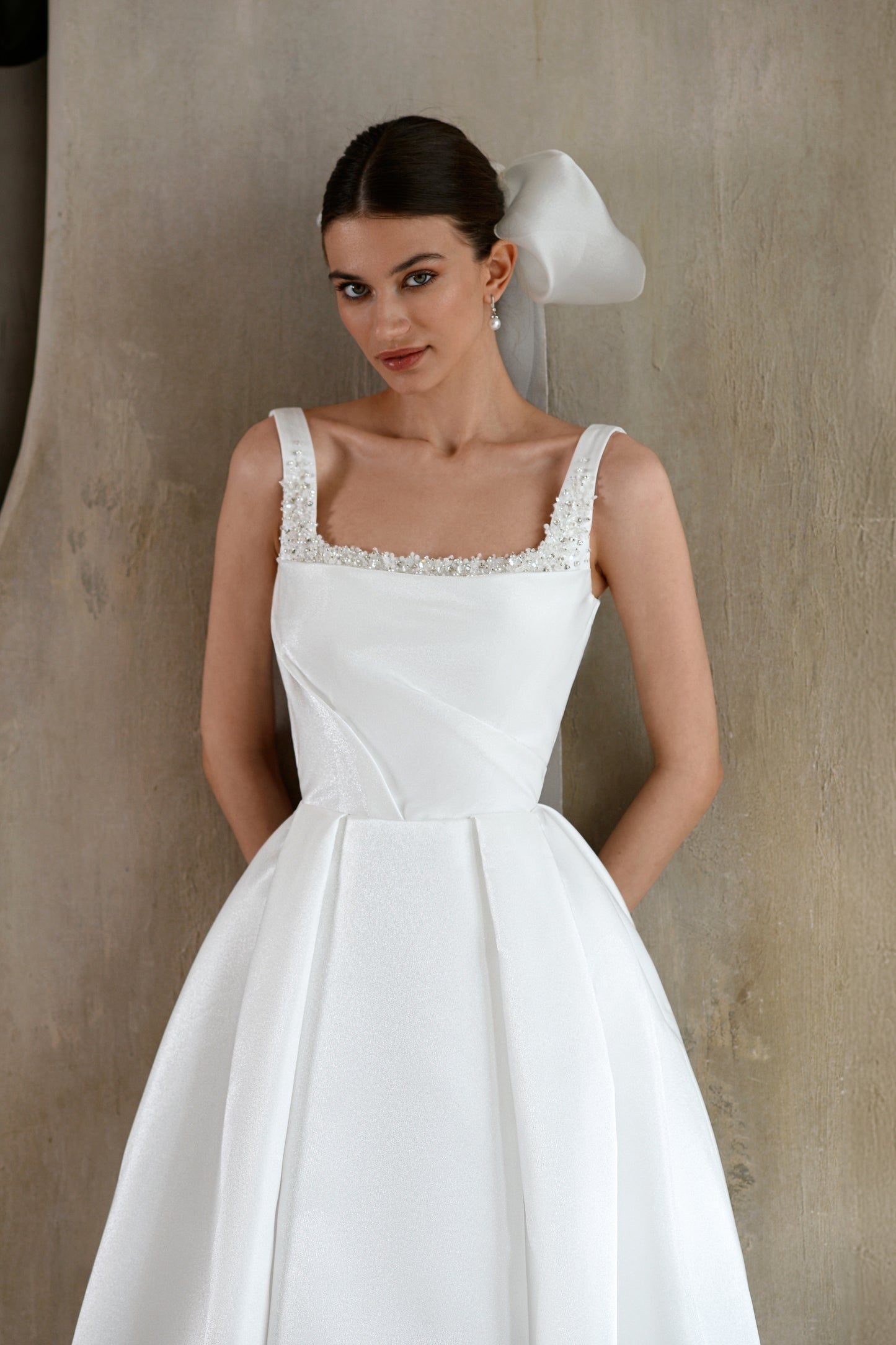 Minimalist sleeveless A-line wedding dress with court train.
