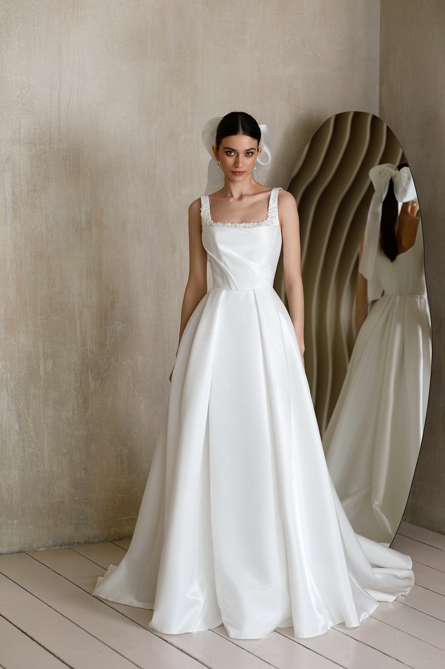 Minimalist sleeveless A-line wedding dress with court train.