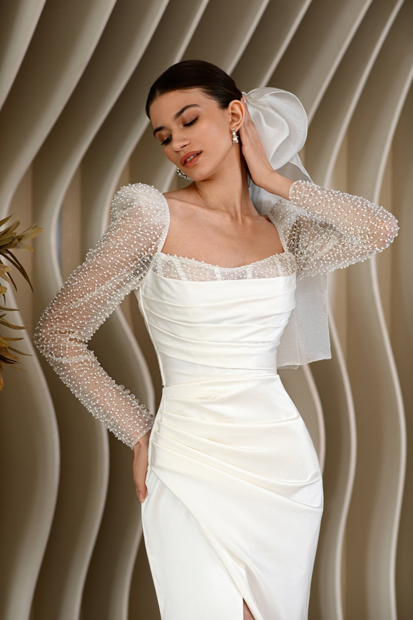 Sheath wedding dress with long sleeves and open back.