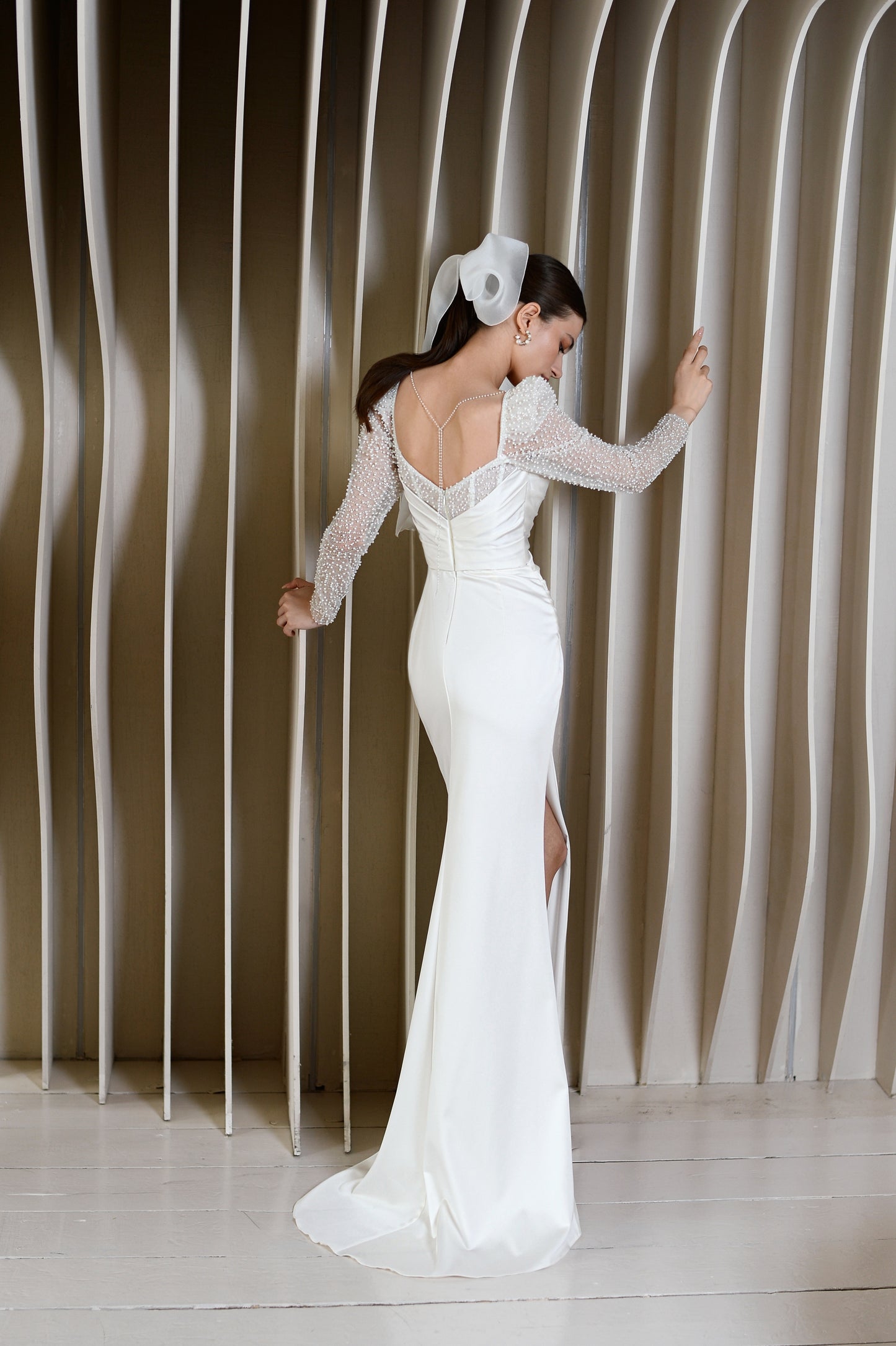 Sheath wedding dress with long sleeves and open back.