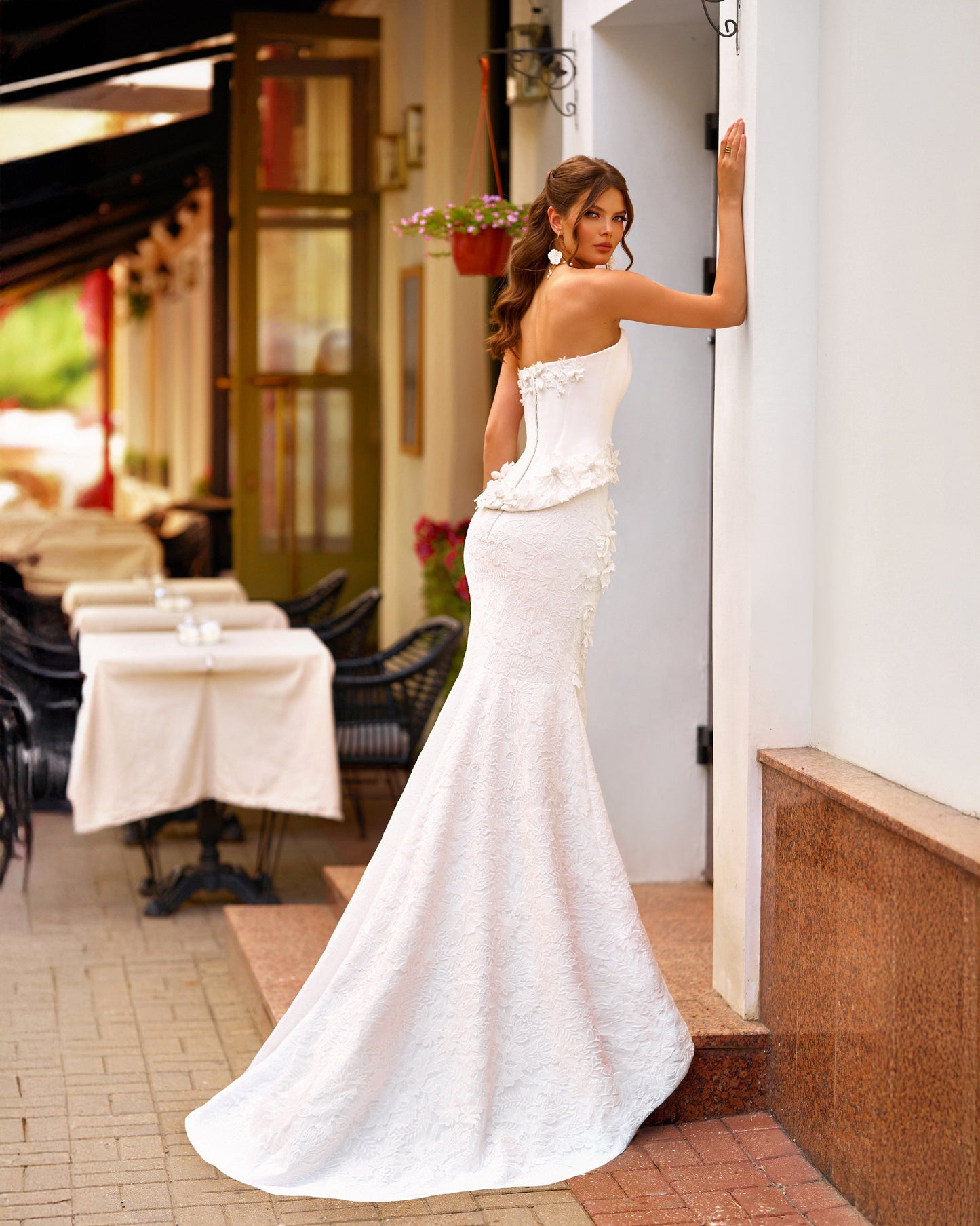 Bride wearing trumpet wedding dress with sleeveless Mikado corset, boat neckline, lace skirt, and sweep train.