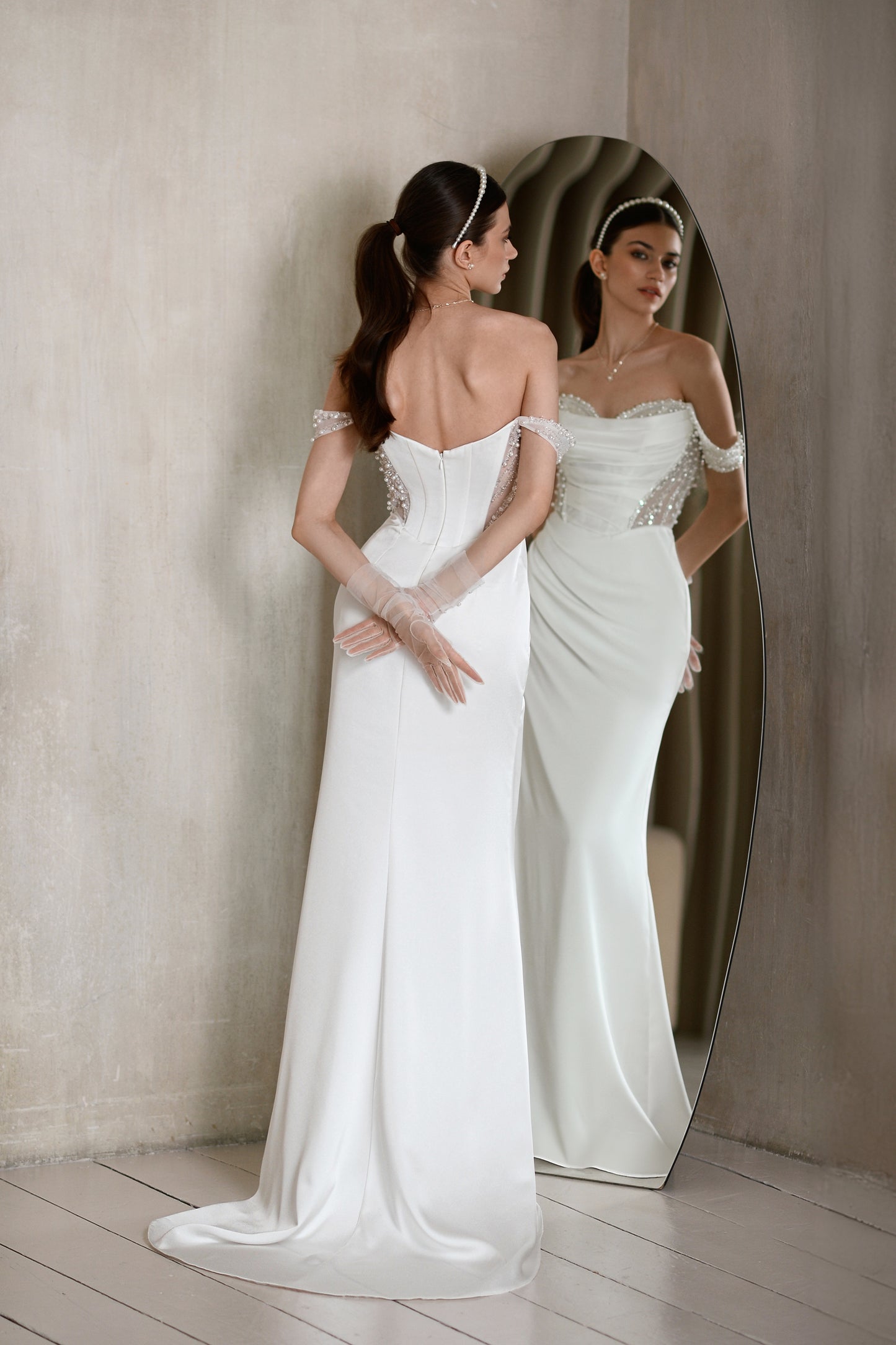 Satin sheath wedding dress with off-the-shoulder straps.