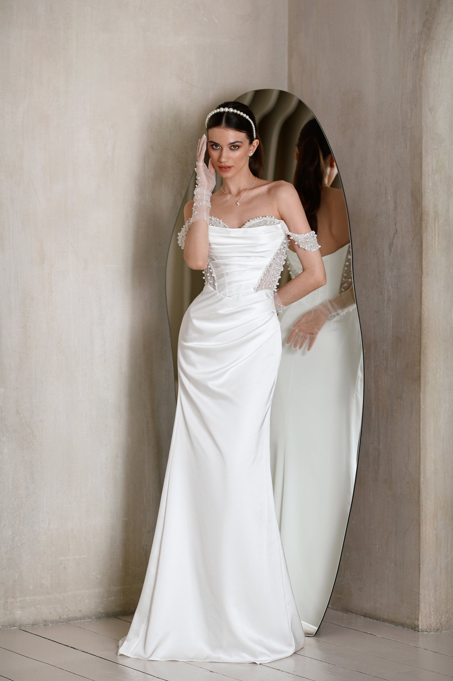 Satin sheath wedding dress with off-the-shoulder straps.