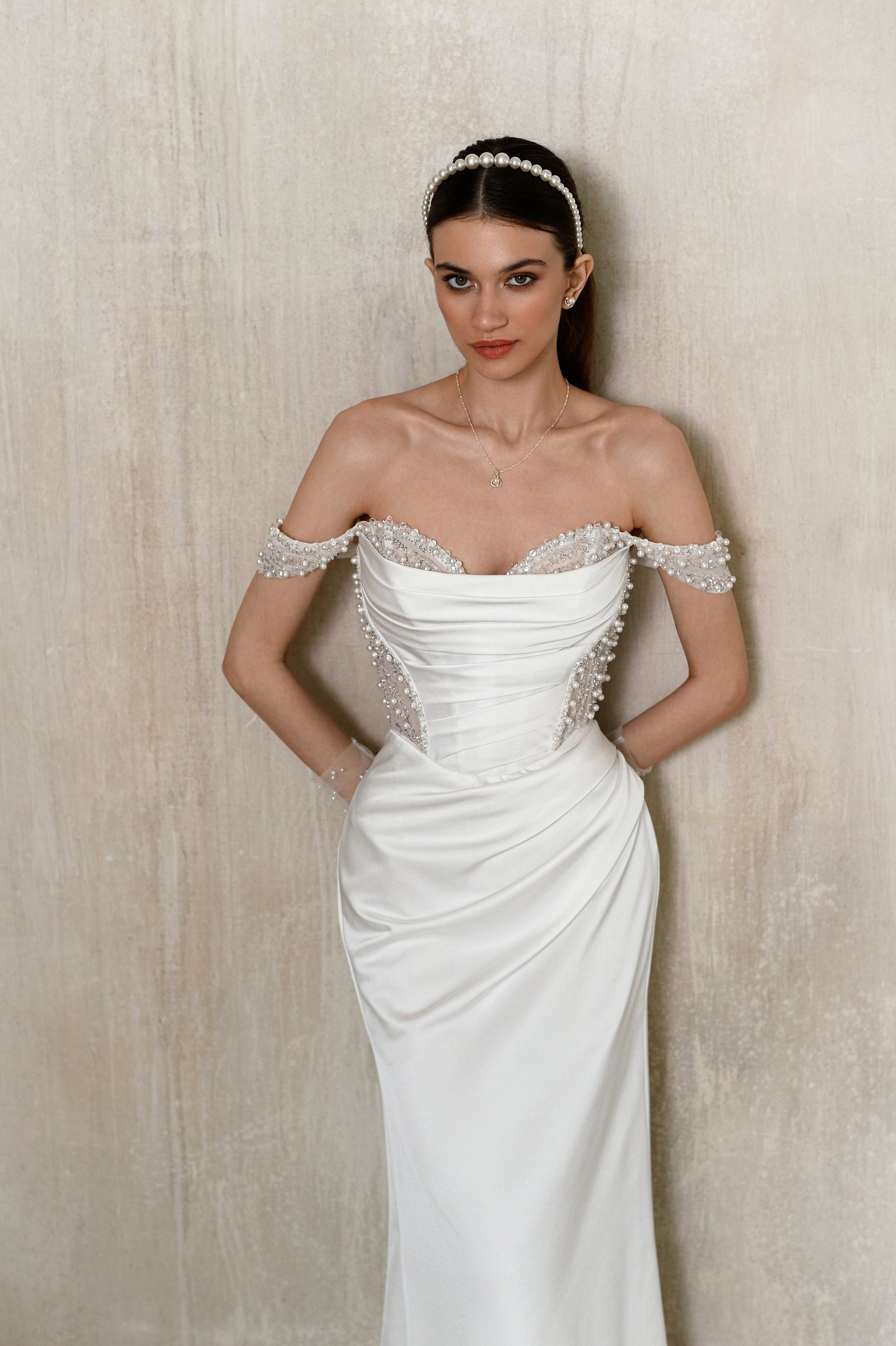 Satin sheath wedding dress with off-the-shoulder straps.