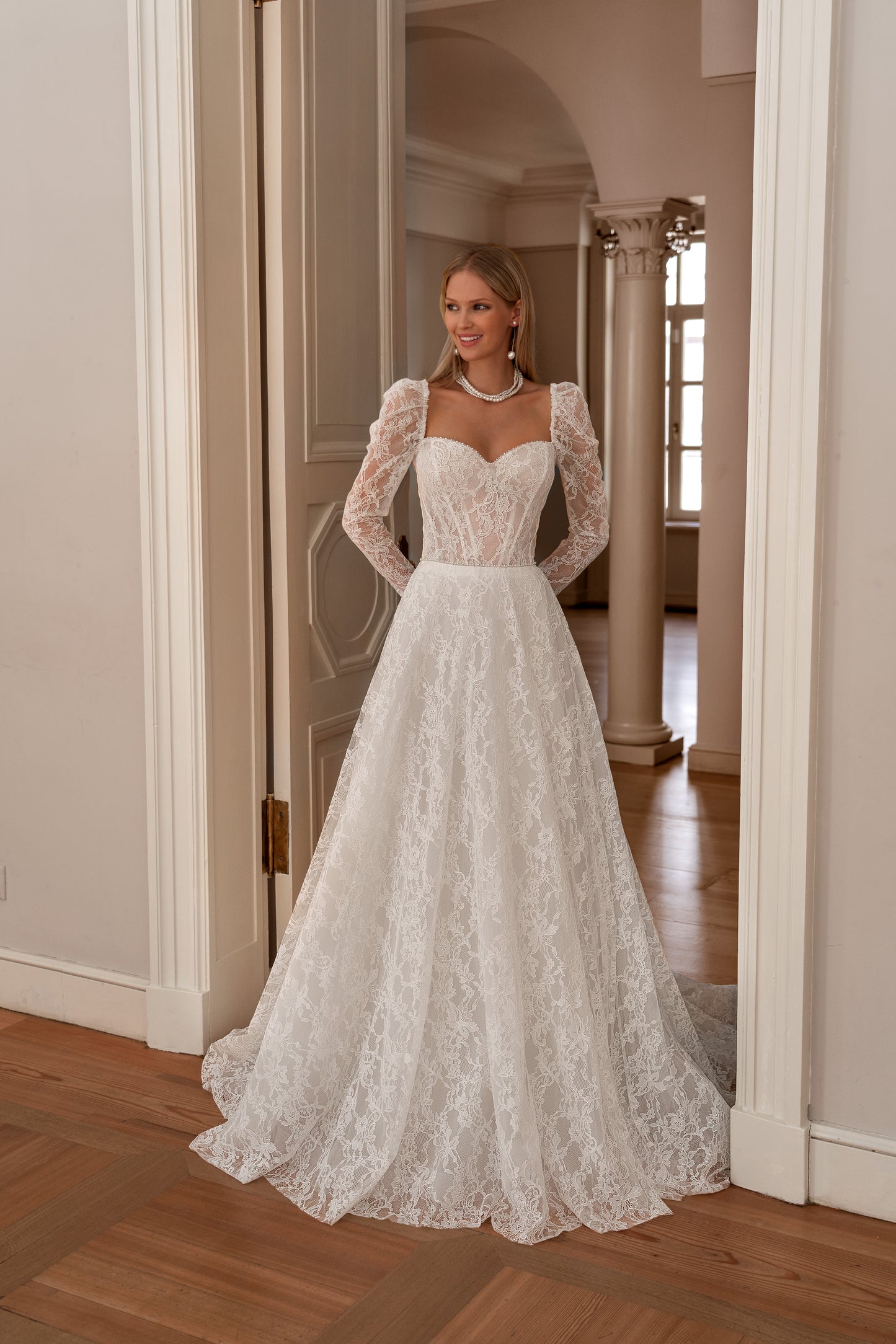A-line wedding dress with long sleeves and open back.
