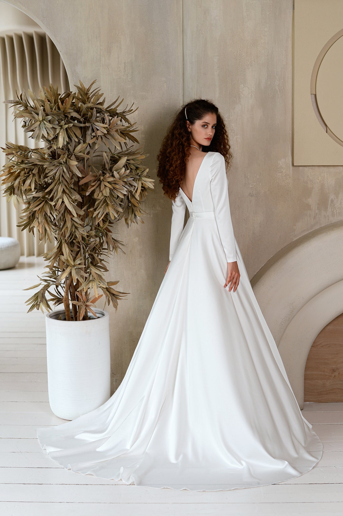 A-line satin wedding dress with long sleeves and V-neck.