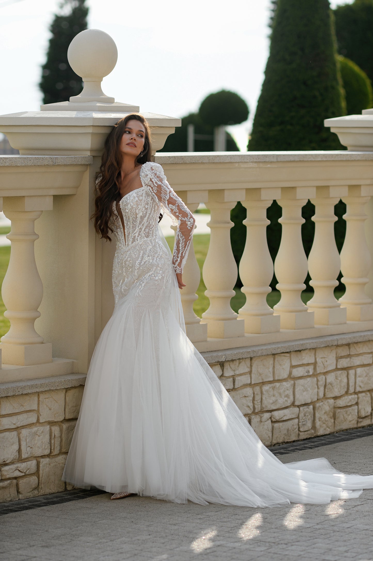 Mermaid wedding dress with long sleeves, bow, and fishtail train