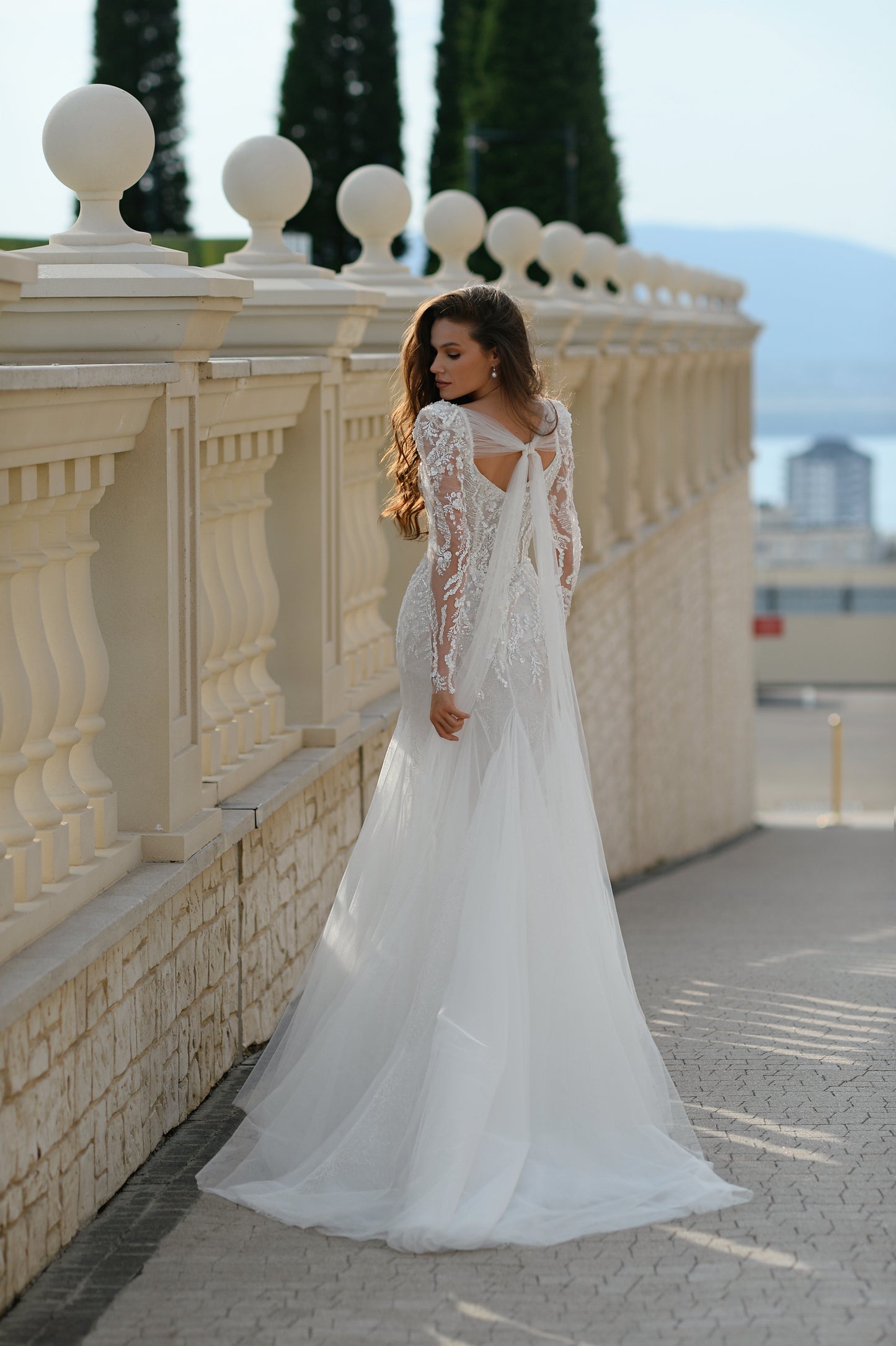 Mermaid wedding dress with long sleeves, bow, and fishtail train