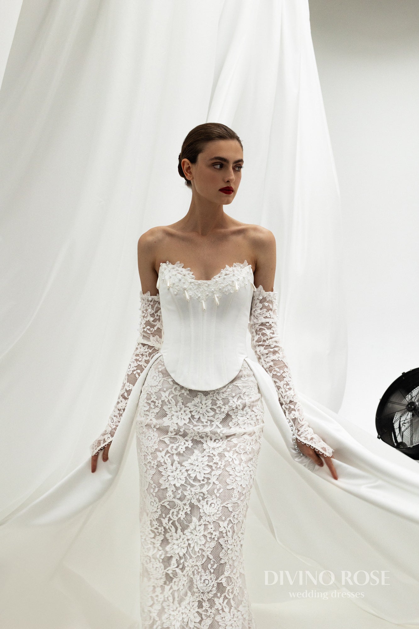 Fitted wedding dress with lace sleeves and corset back.