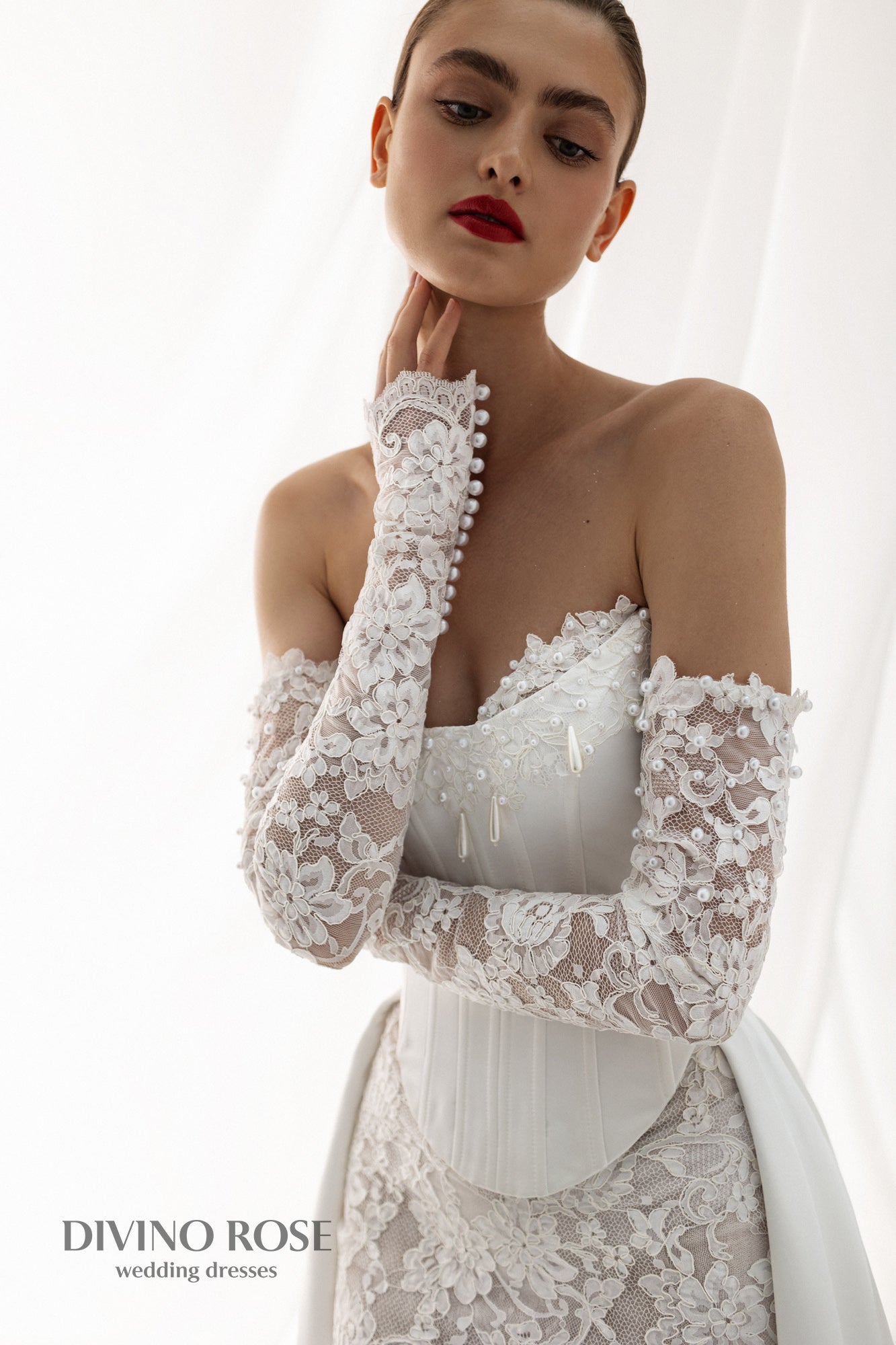 Fitted wedding dress with lace sleeves and corset back.