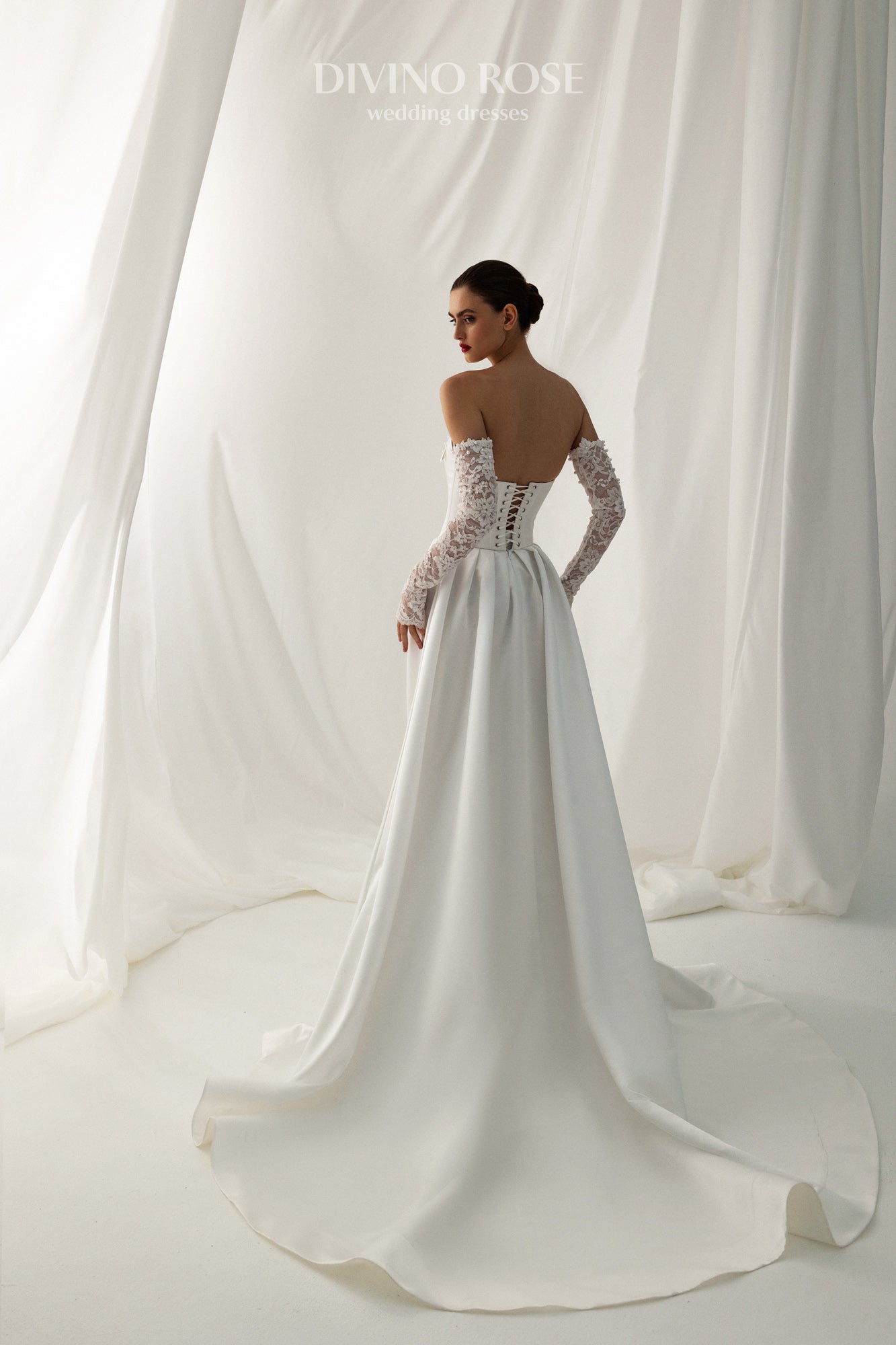 Fitted wedding dress with lace sleeves and corset back.
