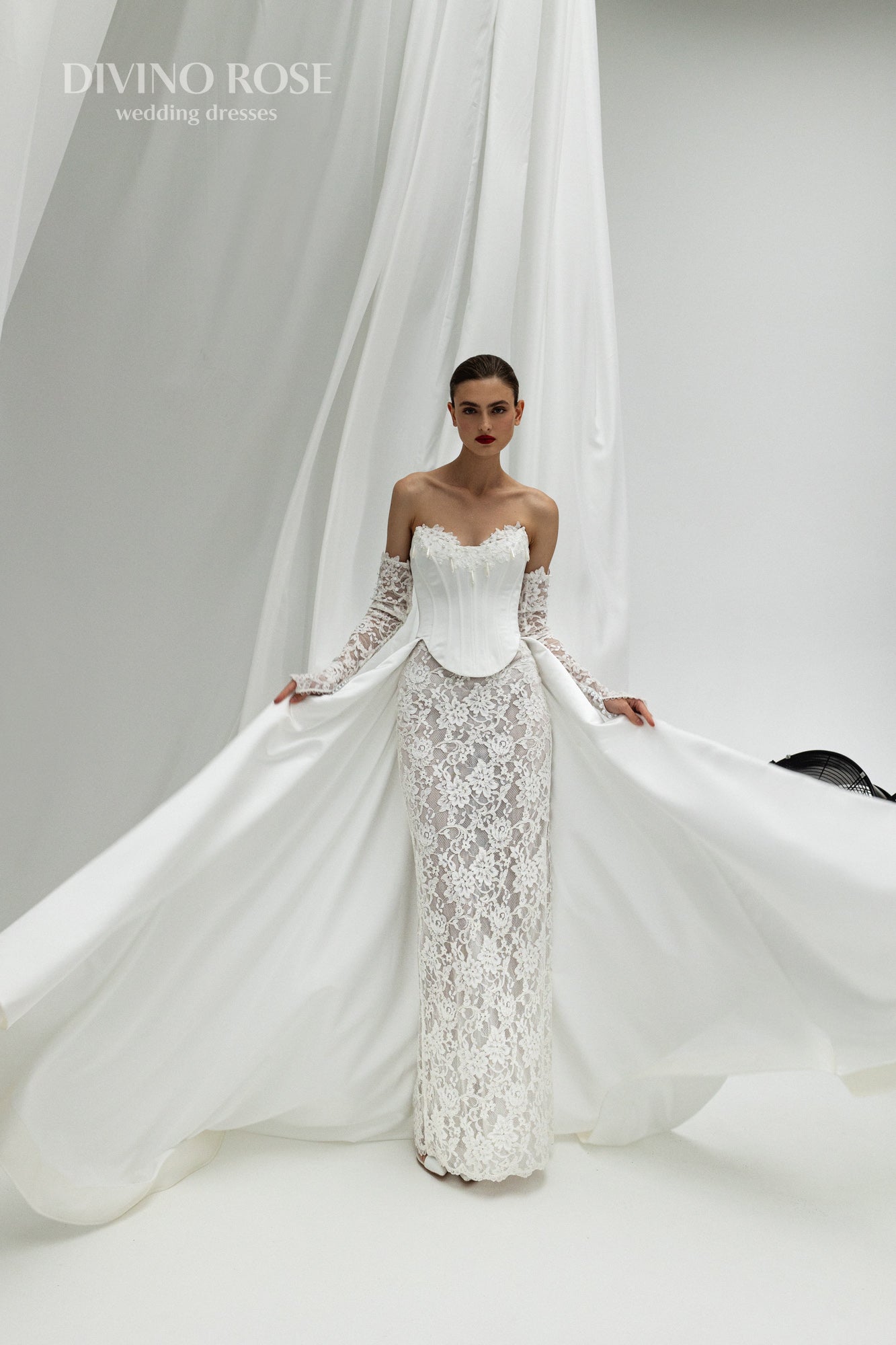 Fitted wedding dress with lace sleeves and corset back.
