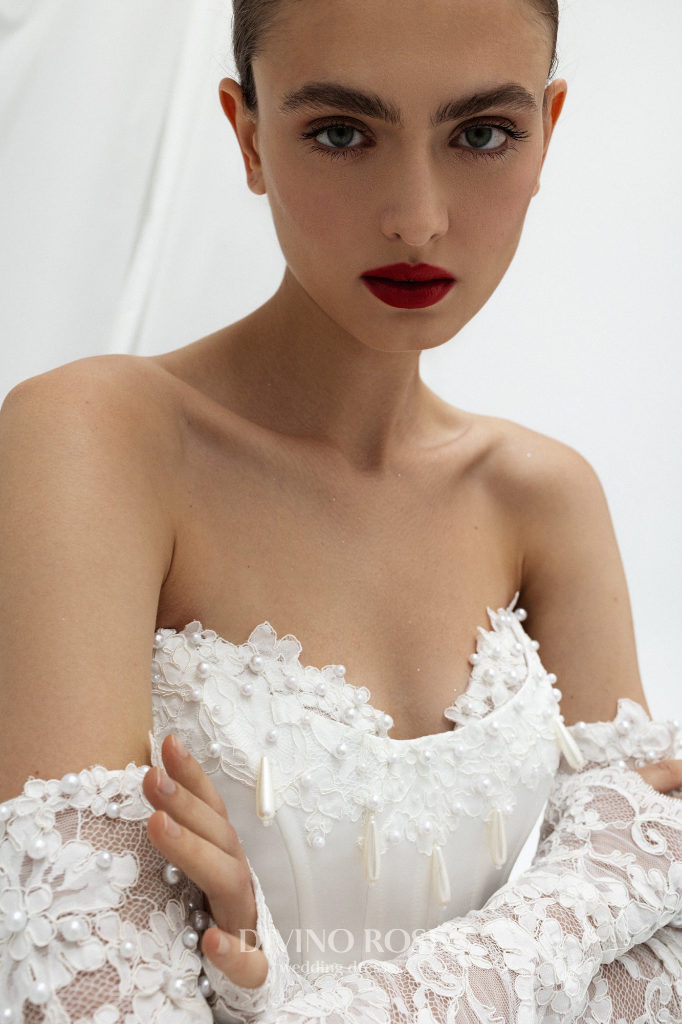 Fitted wedding dress with lace sleeves and corset back.