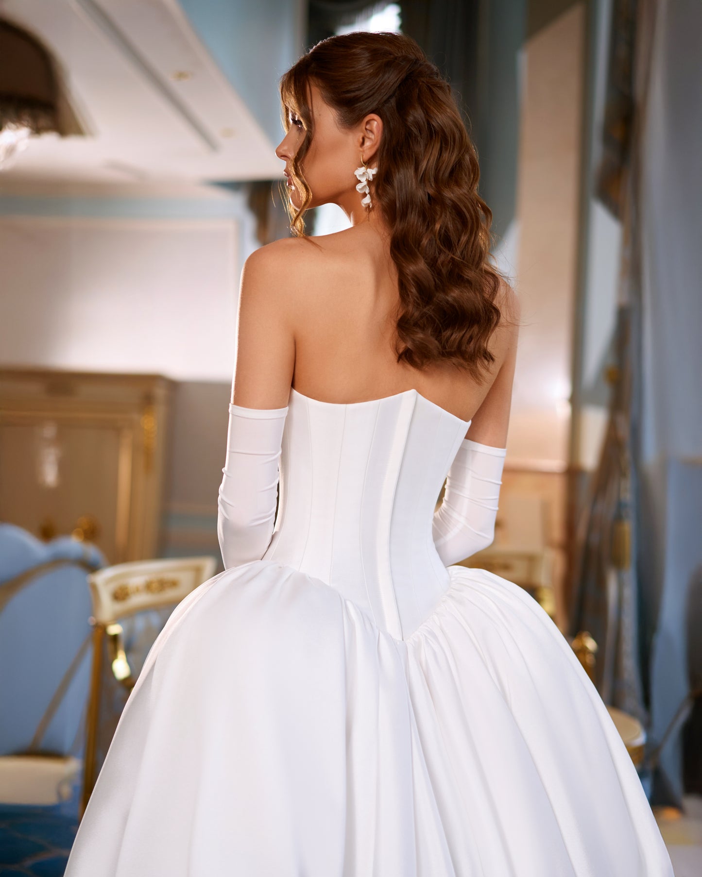 Mikado A-line wedding dress with reverse sweetheart neckline, drop-down waspie corset, sleeveless design, long gloves, zip closure, and flowing chapel train for elegant modern bridal look