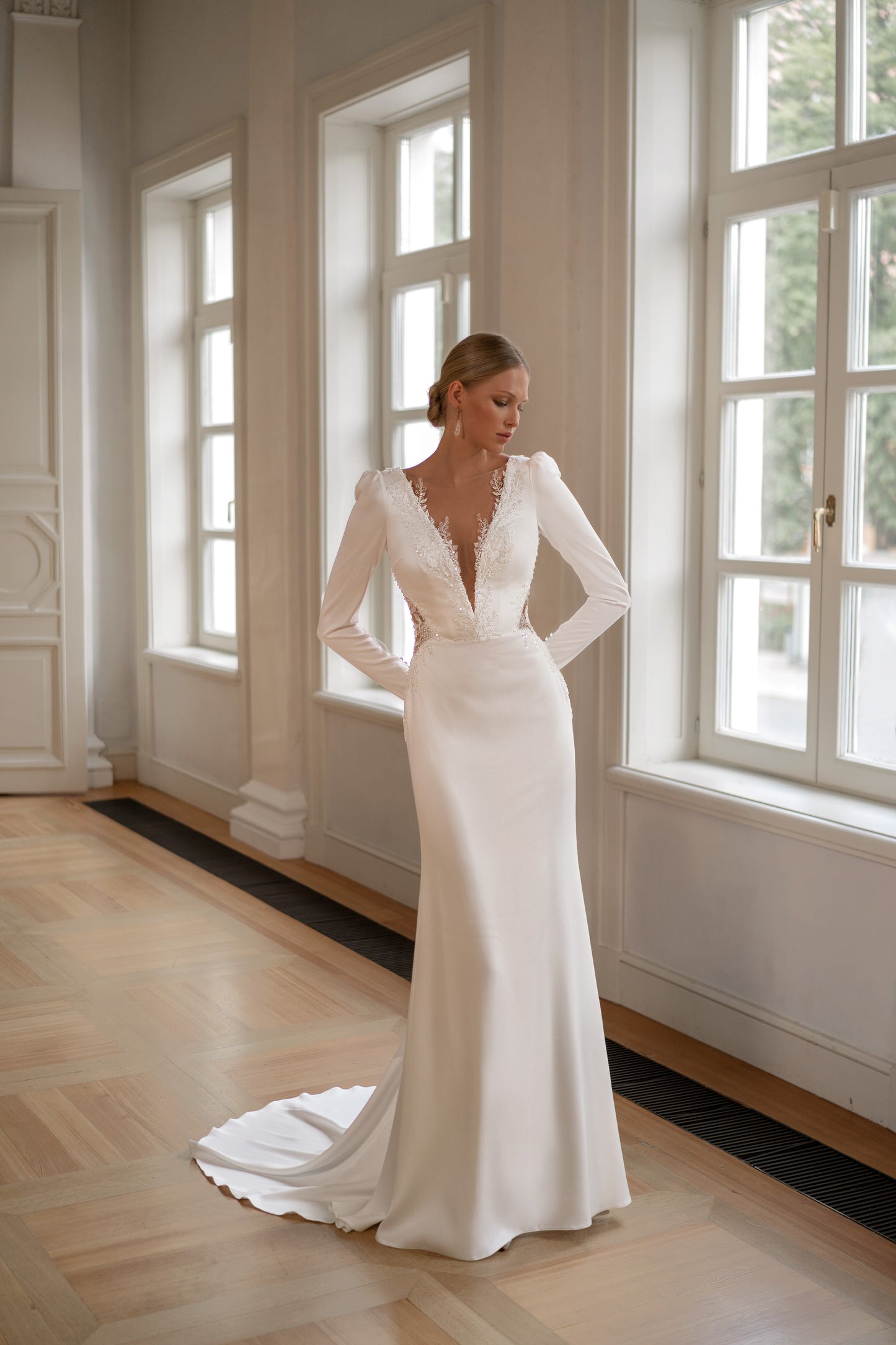 Satin long sleeve sheath wedding dress with deep-V neckline.