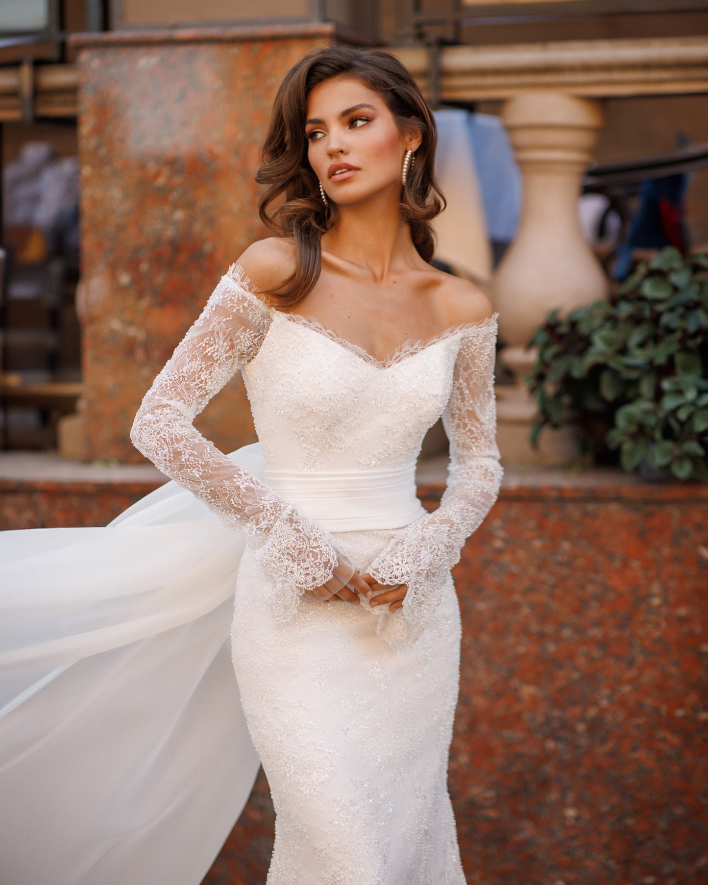 Mermaid lace wedding dress with long sleeves and V-neckline.