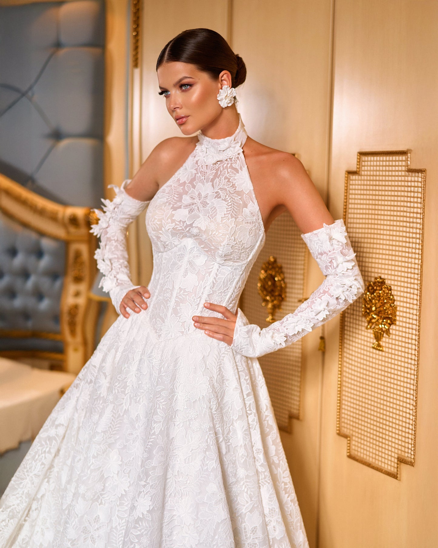 Lace A-line halter wedding dress with long removable sleeves adorned with 3D flowers, drop-down waist waspie corset, open lace-up back, and flowing chapel train for romantic bridal look