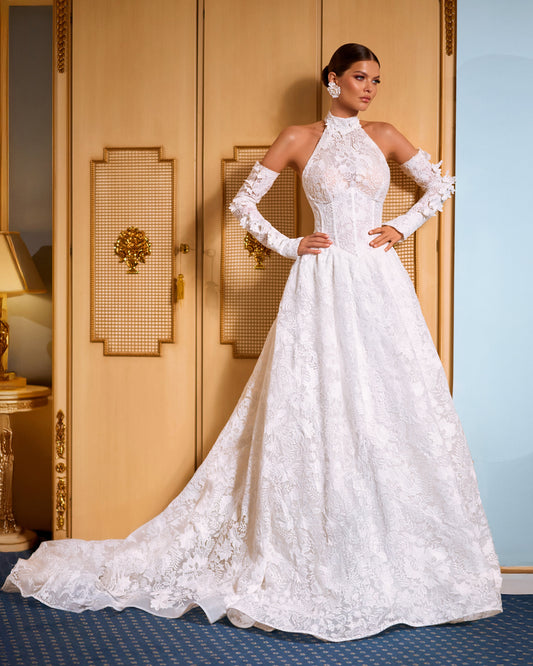 Lace A-line halter wedding dress with long removable sleeves adorned with 3D flowers, drop-down waist waspie corset, open lace-up back, and flowing chapel train for romantic bridal look