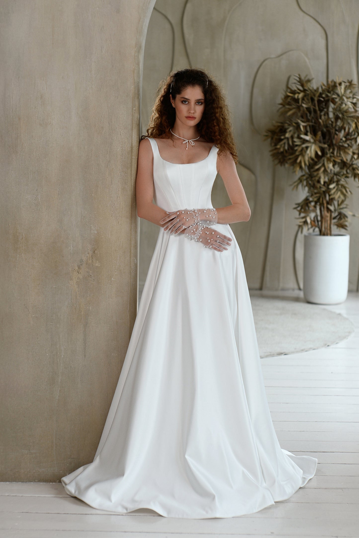 Minimalist A-line sleeveless wedding dress with court train.