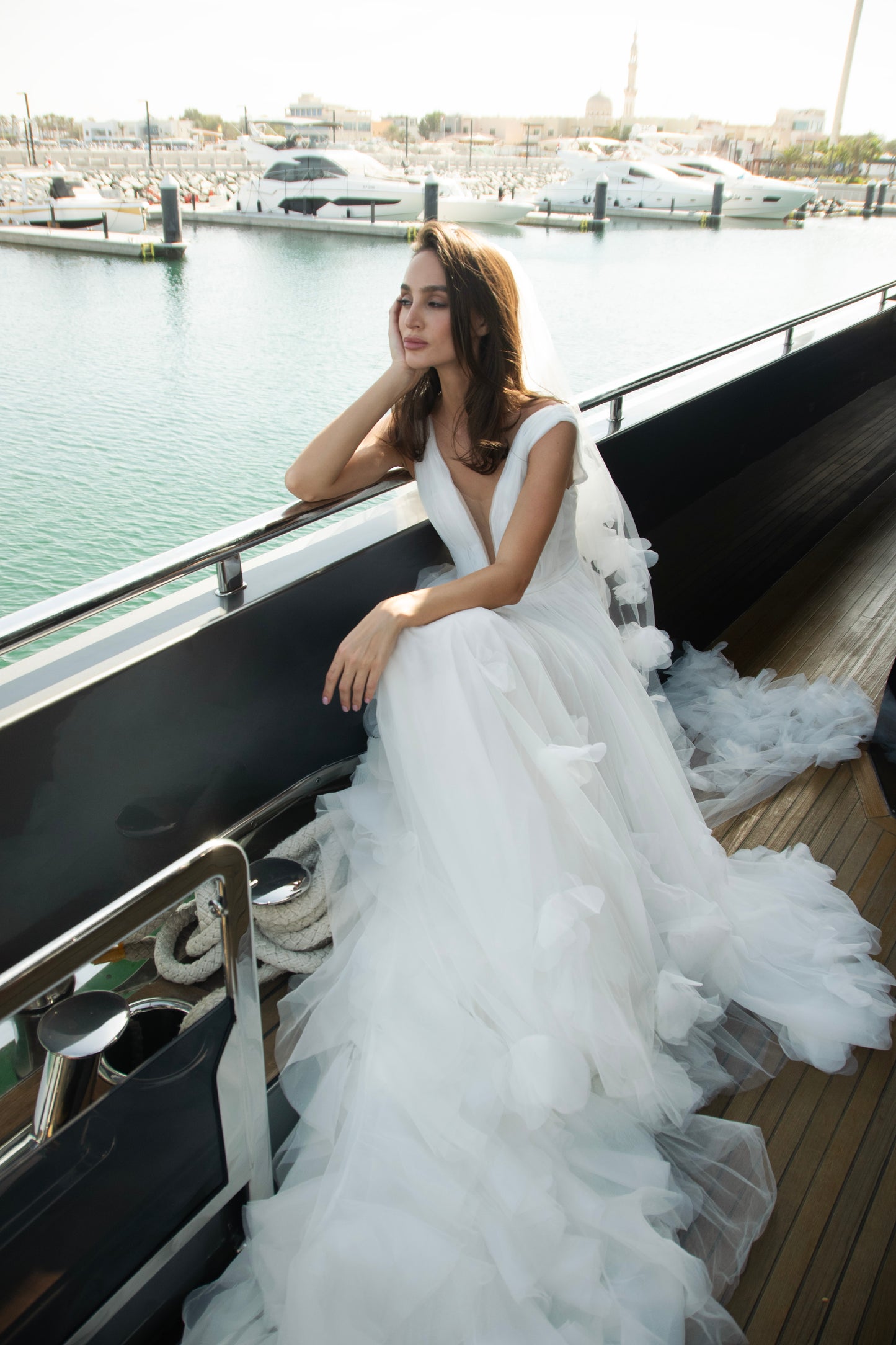 Ethereal tulle ball gown with deep V-neckline and layered airy skirt.