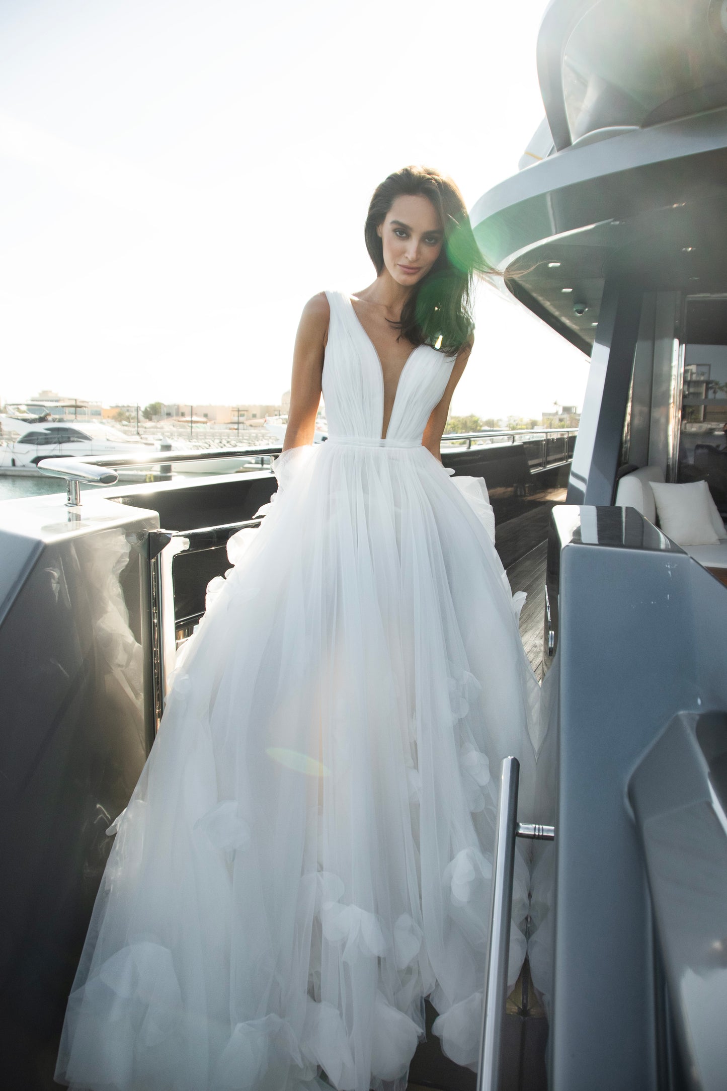 Ethereal tulle ball gown with deep V-neckline and layered airy skirt.